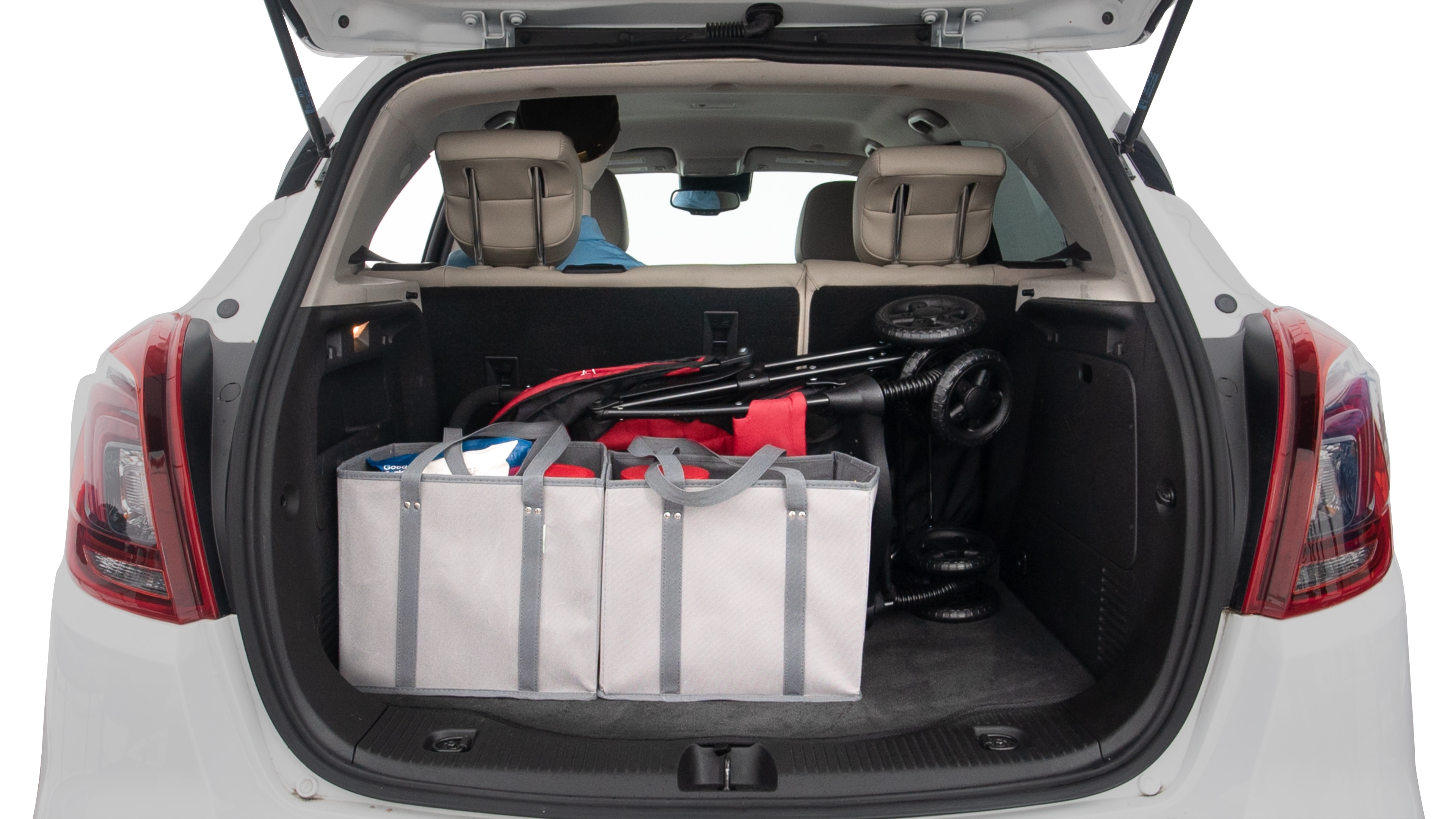 The trunk lid is open showing full view of the trunk. A baby stroller and three grocery carriers are placed inside.