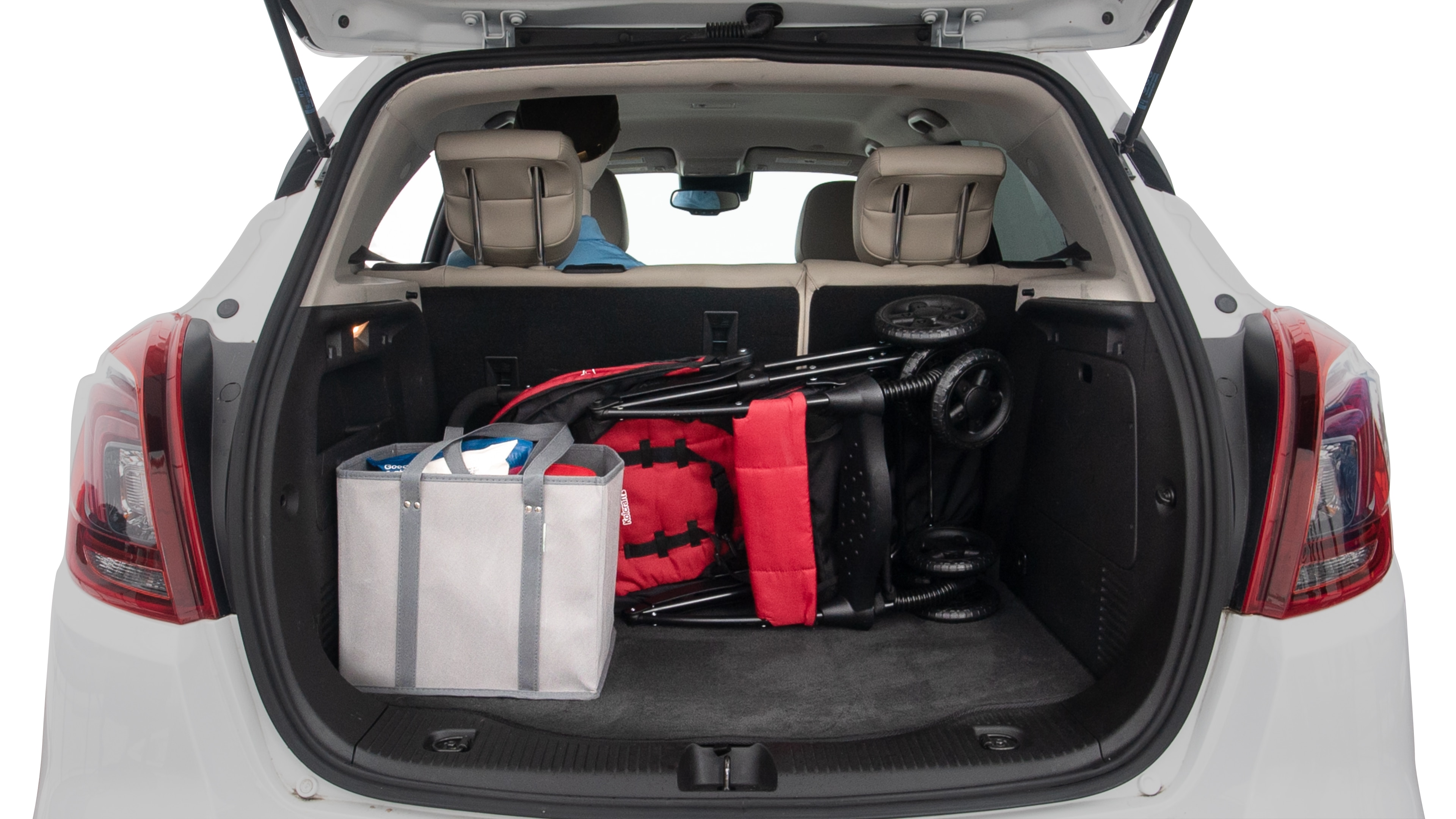 The trunk lid is open showing full view of the trunk. A baby stroller and three grocery carriers are placed inside.