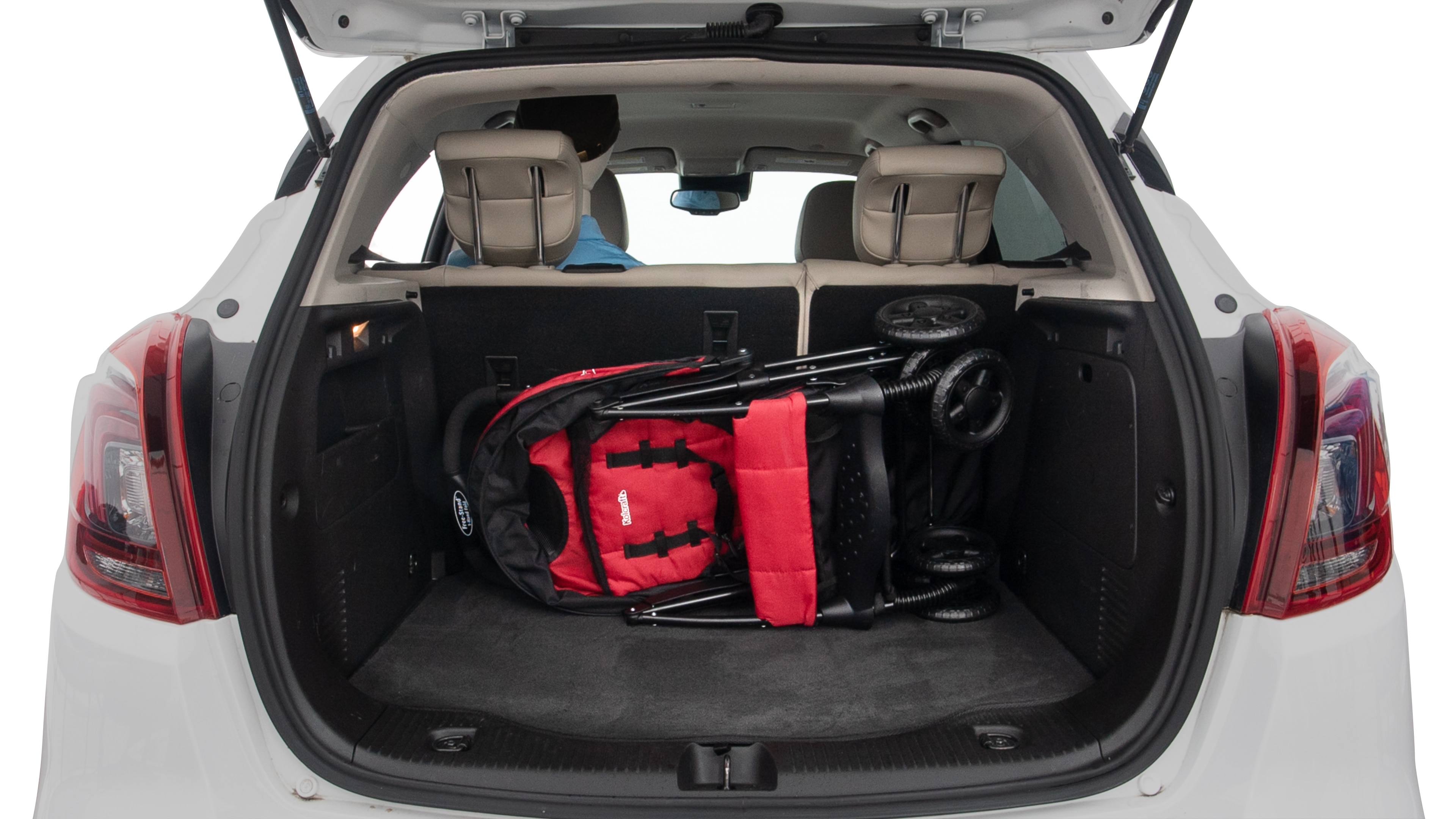 The trunk lid is open showing full view of the trunk. A baby stroller and three grocery carriers are placed inside.