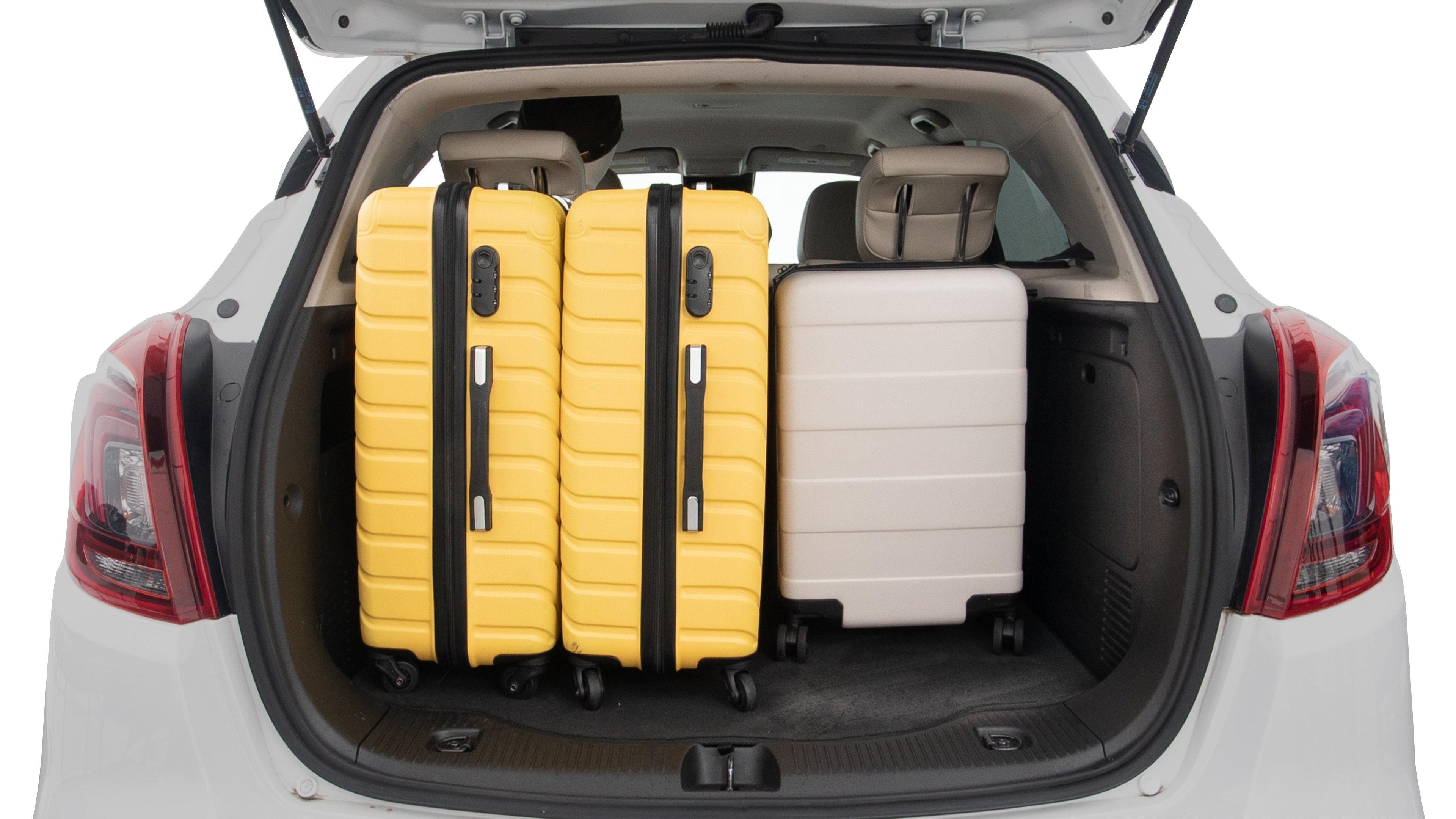 The trunk lid is open, showing full view of the trunk space. Two large and two small suitcases are placed inside.