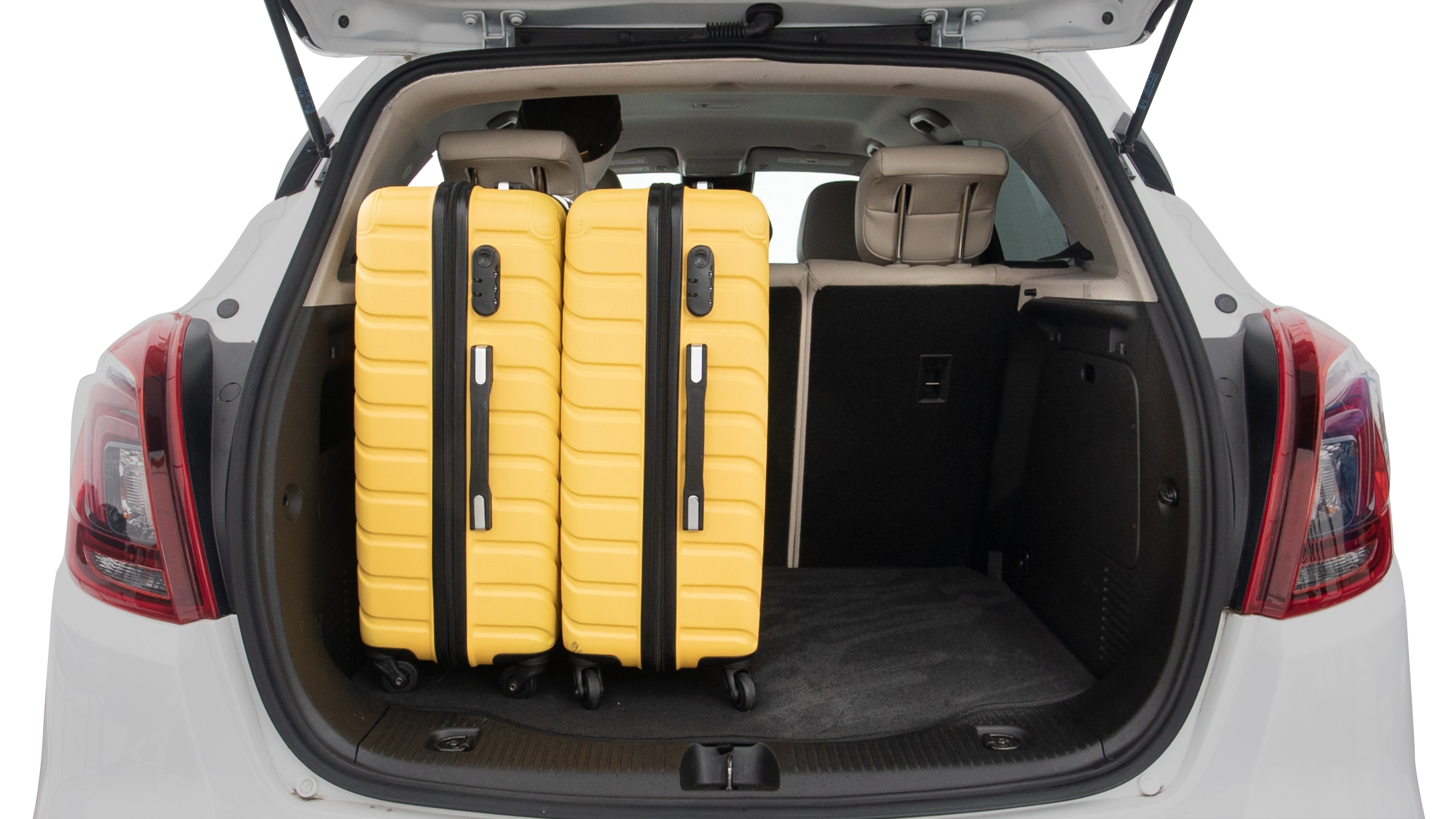 The trunk lid is open, showing full view of the trunk space. Two large and two small suitcases are placed inside.