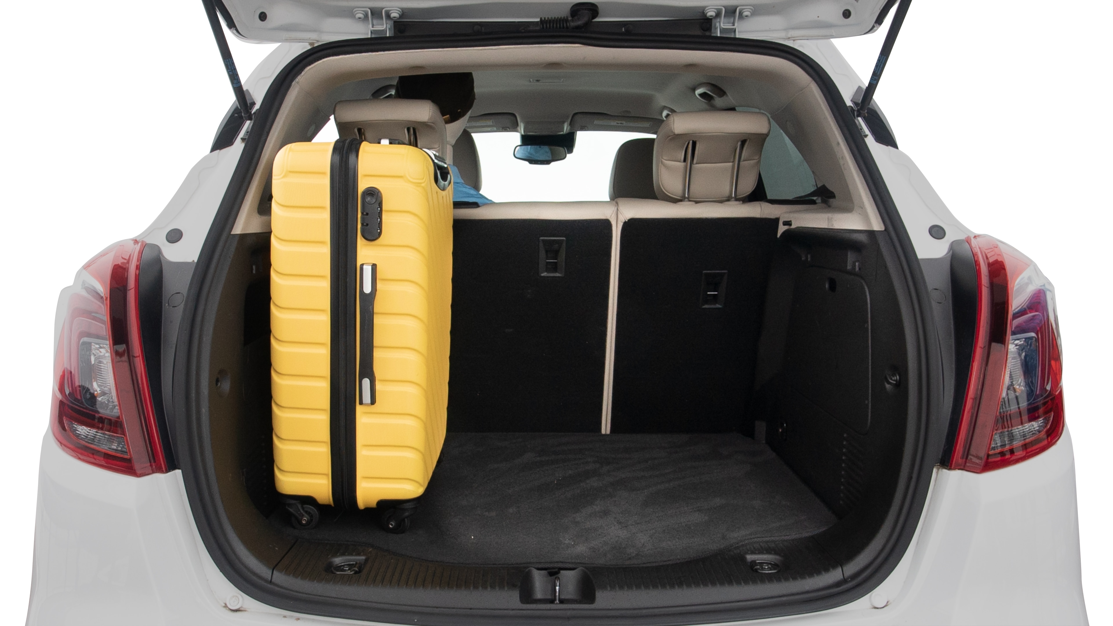 The trunk lid is open, showing full view of the trunk space. Two large and two small suitcases are placed inside.