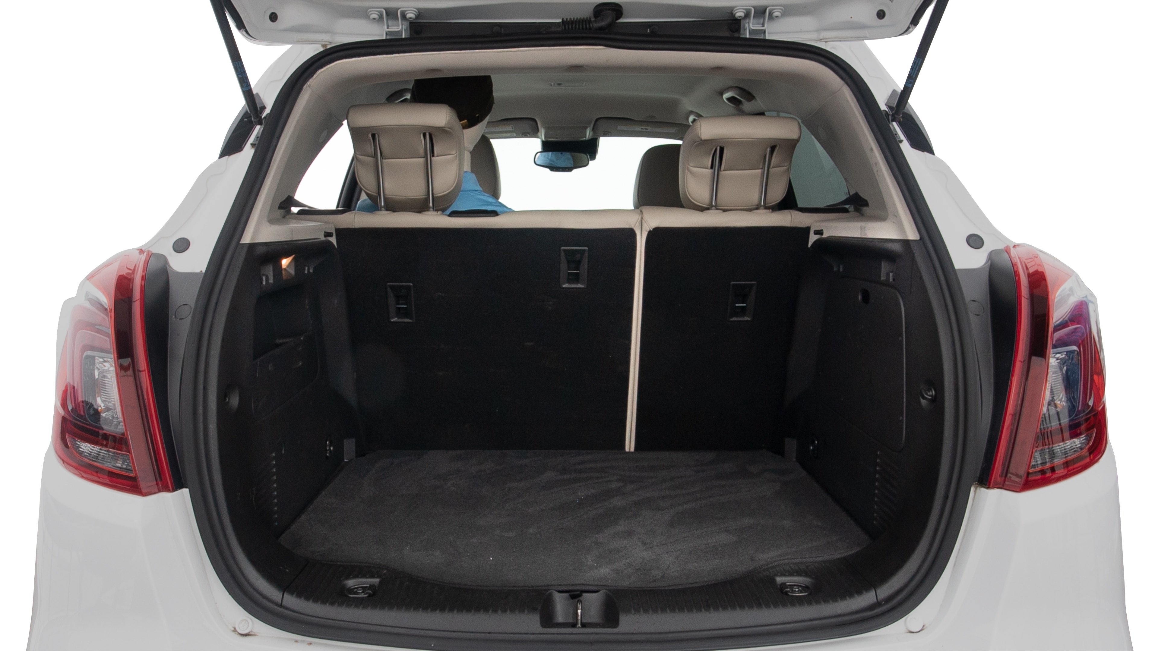 The trunk lid is open, showing full view of the trunk space. Two large and two small suitcases are placed inside.