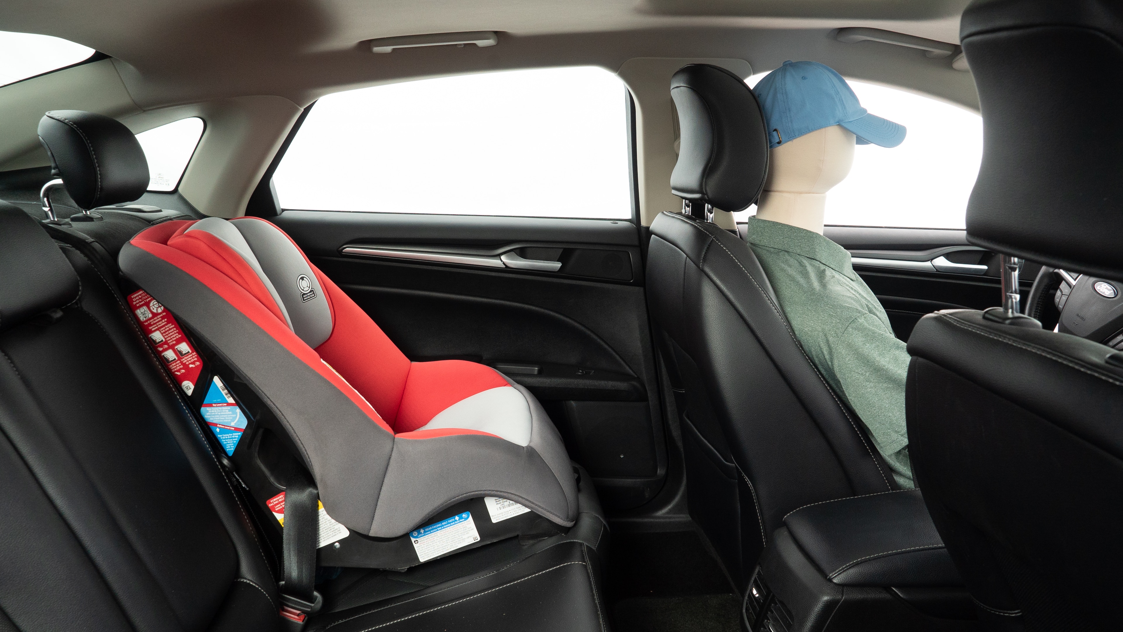 A series of second-row backseat photos is shown including one seating a baby seat and one seating a 6'1" mannequin.