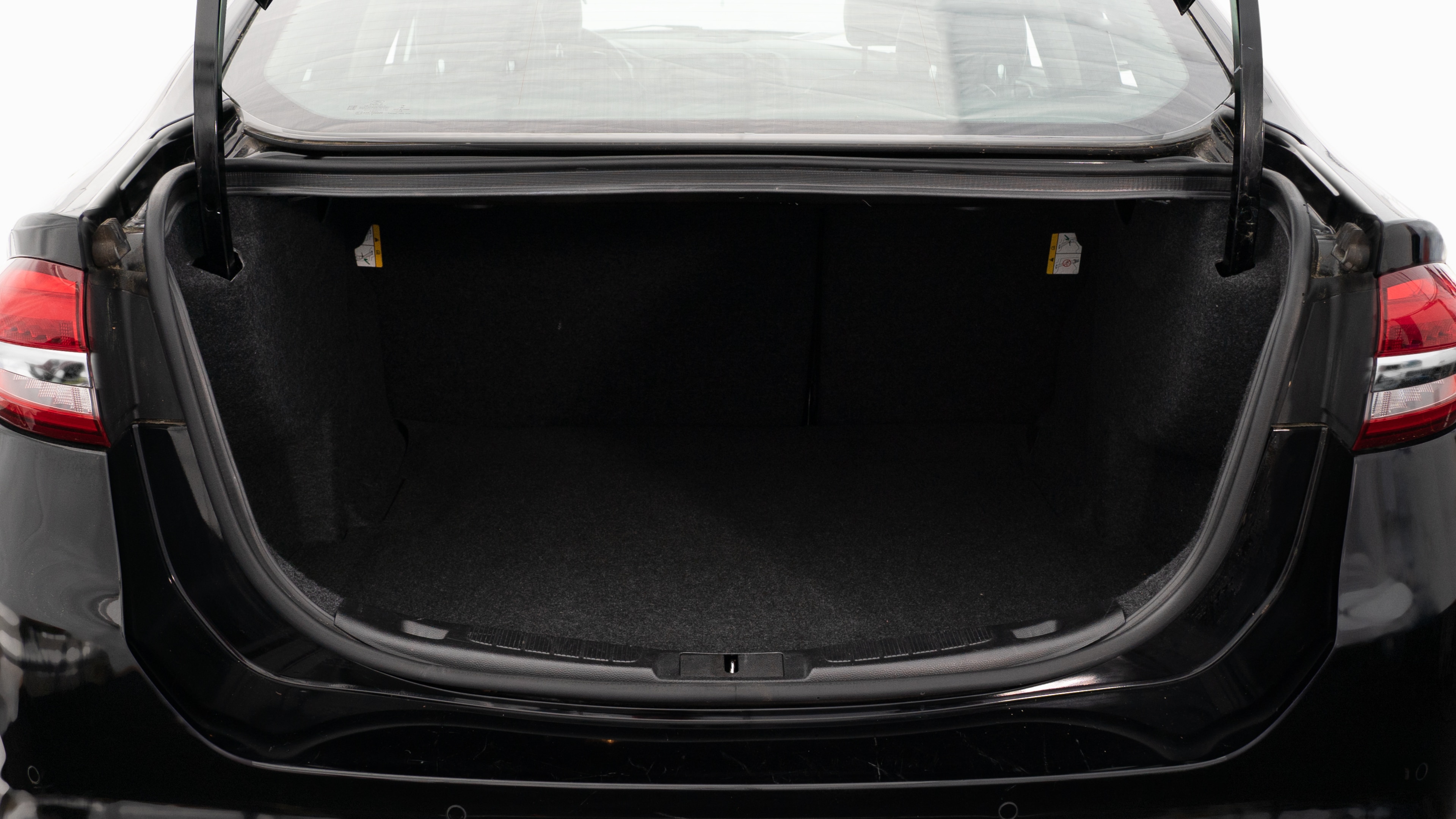 The trunk lid is open showing full view of the trunk. A baby stroller, two grocery carriers, two camping chairs in the carrying bag, and a set of golf clubs are placed inside.