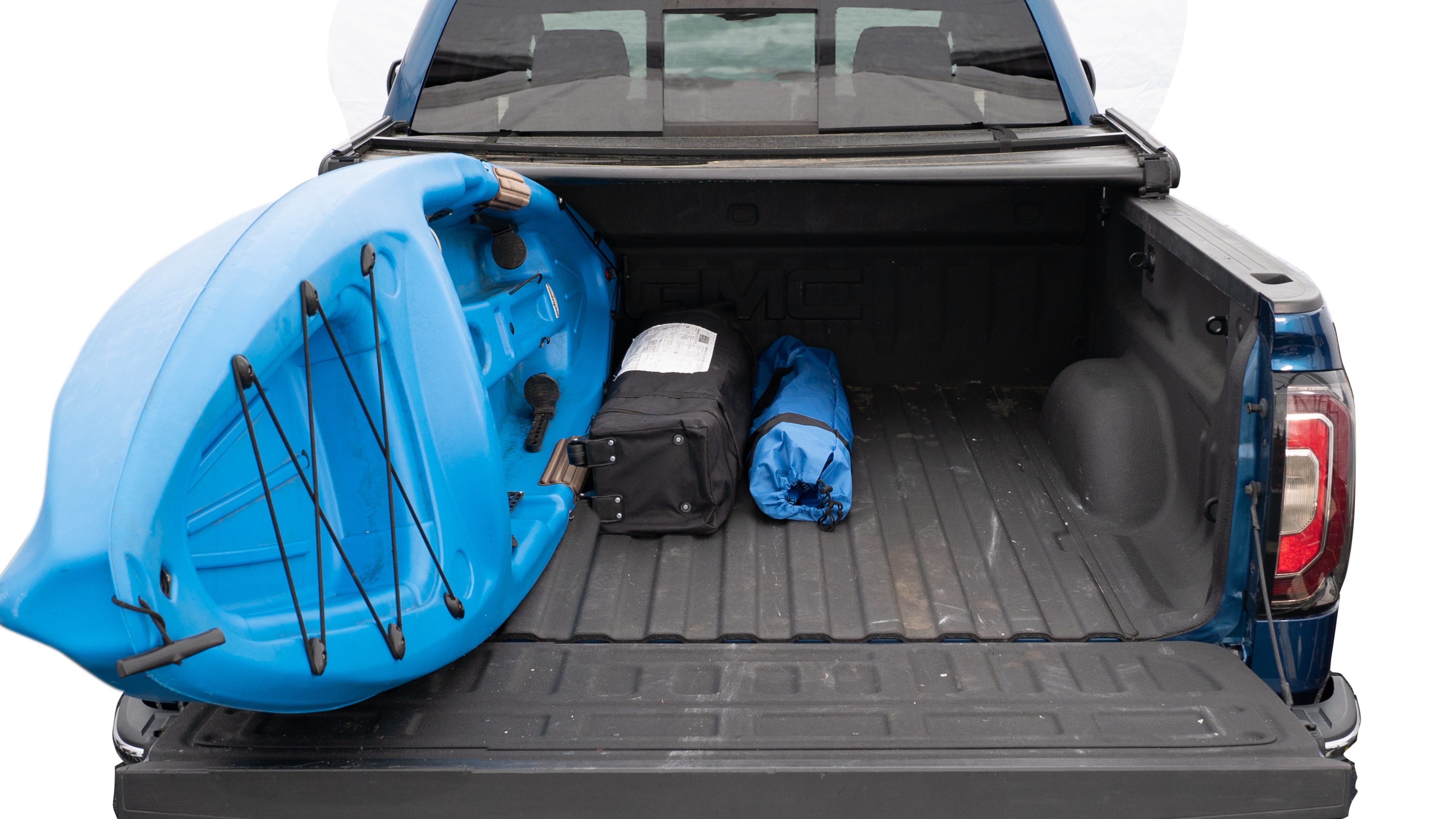 The trunk area is open giving a full view of the trunk area. A cooler, two camping chairs, a tailgate tent and a kayak are placed inside.