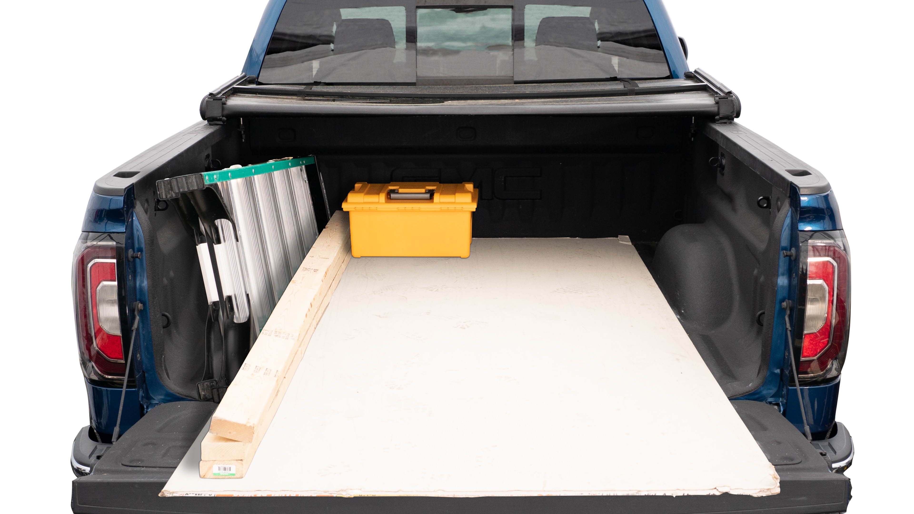The trunk area is open giving a full view of the trunk area. A ladder, three 2 by 4 framing studs, two toolboxes and a 4 by 8 drywall sheet are placed inside.