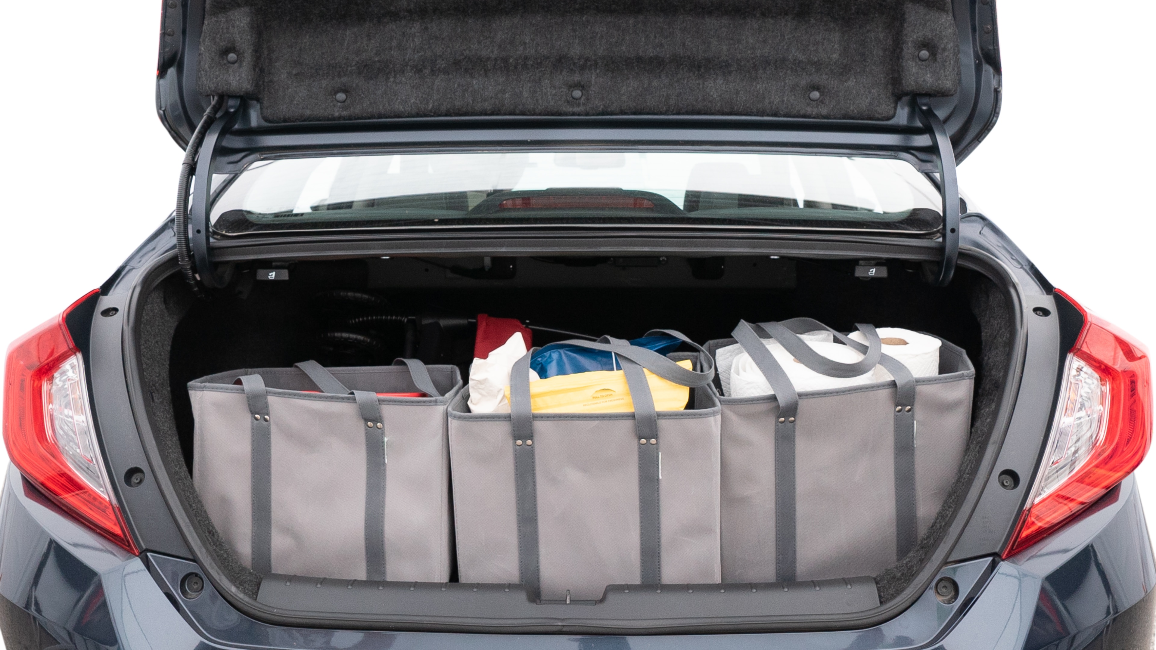 The trunk lid is open showing full view of the trunk. A baby stroller, three grocery carriers, two camping chairs in the carrying bag, and a set of golf clubs are placed inside.