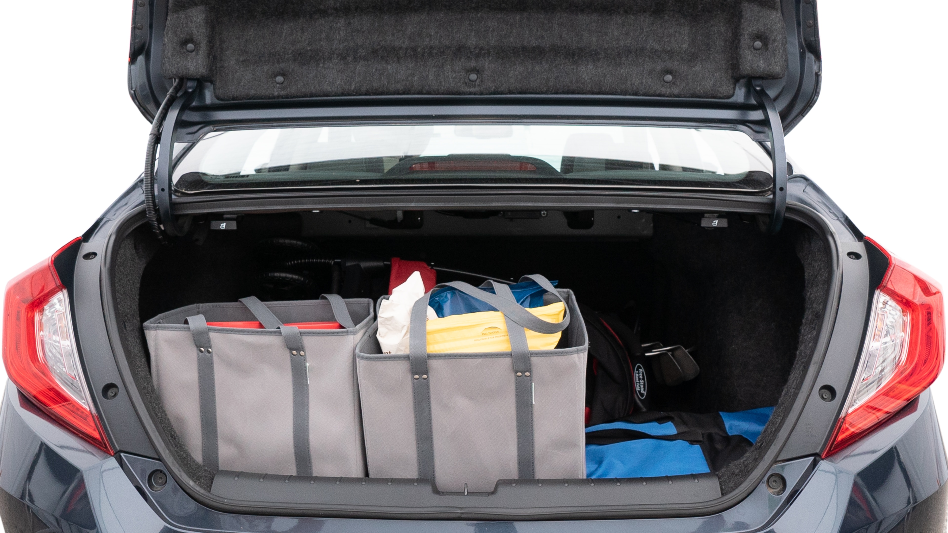 The trunk lid is open showing full view of the trunk. A baby stroller, three grocery carriers, two camping chairs in the carrying bag, and a set of golf clubs are placed inside.