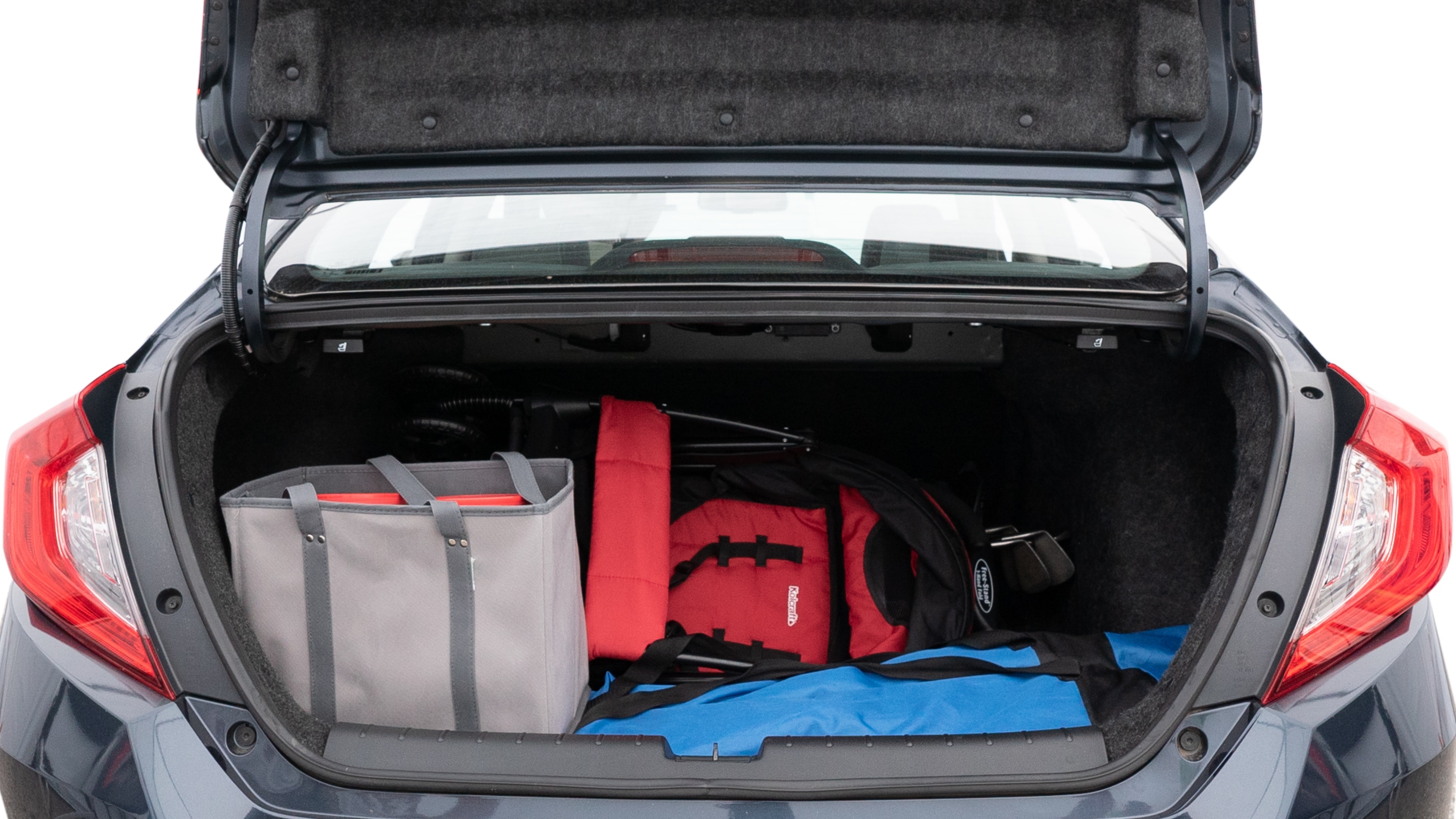 The trunk lid is open showing full view of the trunk. A baby stroller, three grocery carriers, two camping chairs in the carrying bag, and a set of golf clubs are placed inside.