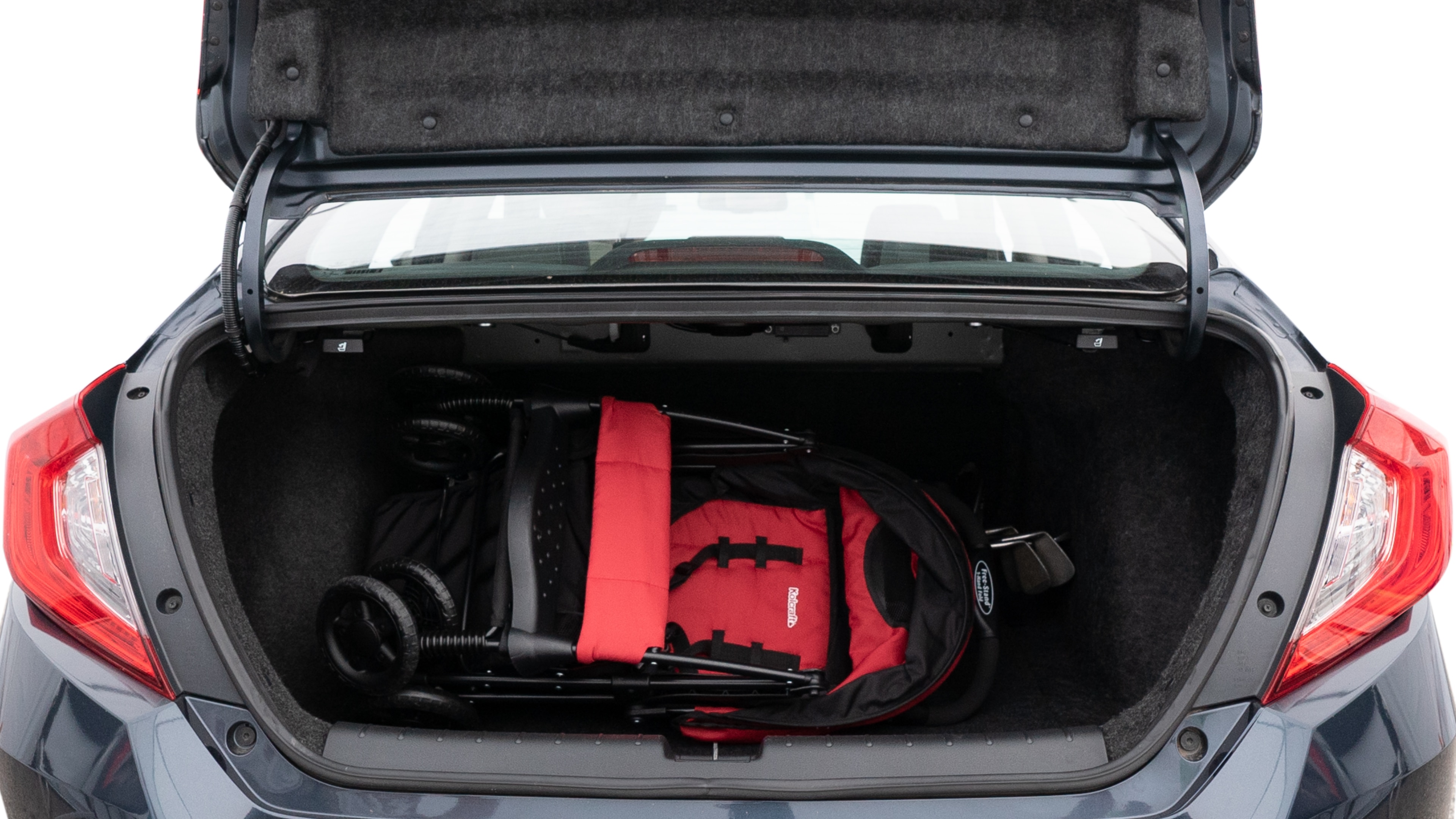 The trunk lid is open showing full view of the trunk. A baby stroller, three grocery carriers, two camping chairs in the carrying bag, and a set of golf clubs are placed inside.