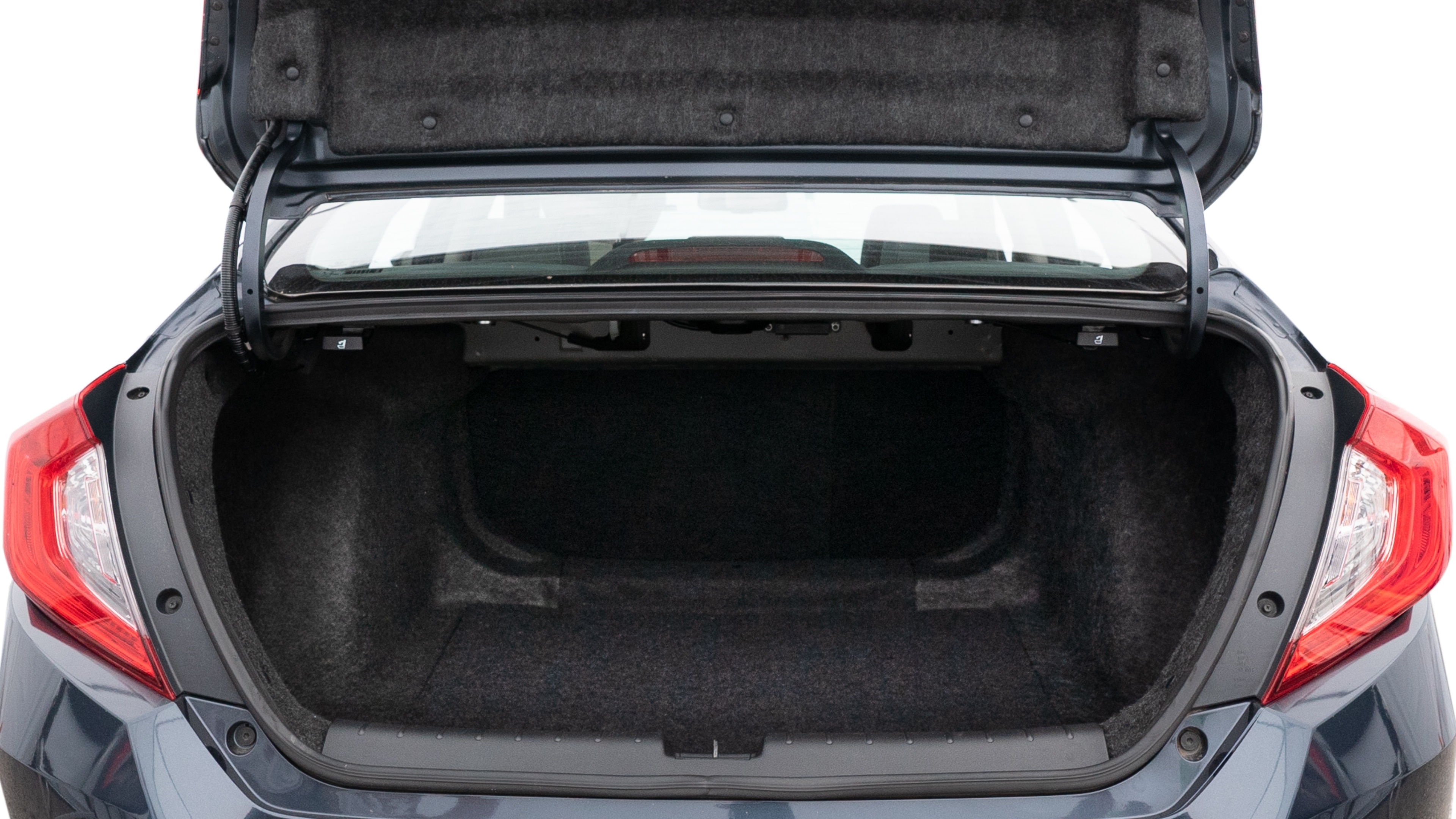 The trunk lid is open, showing full view of the trunk space. Two medium and two small suitcases are placed inside.