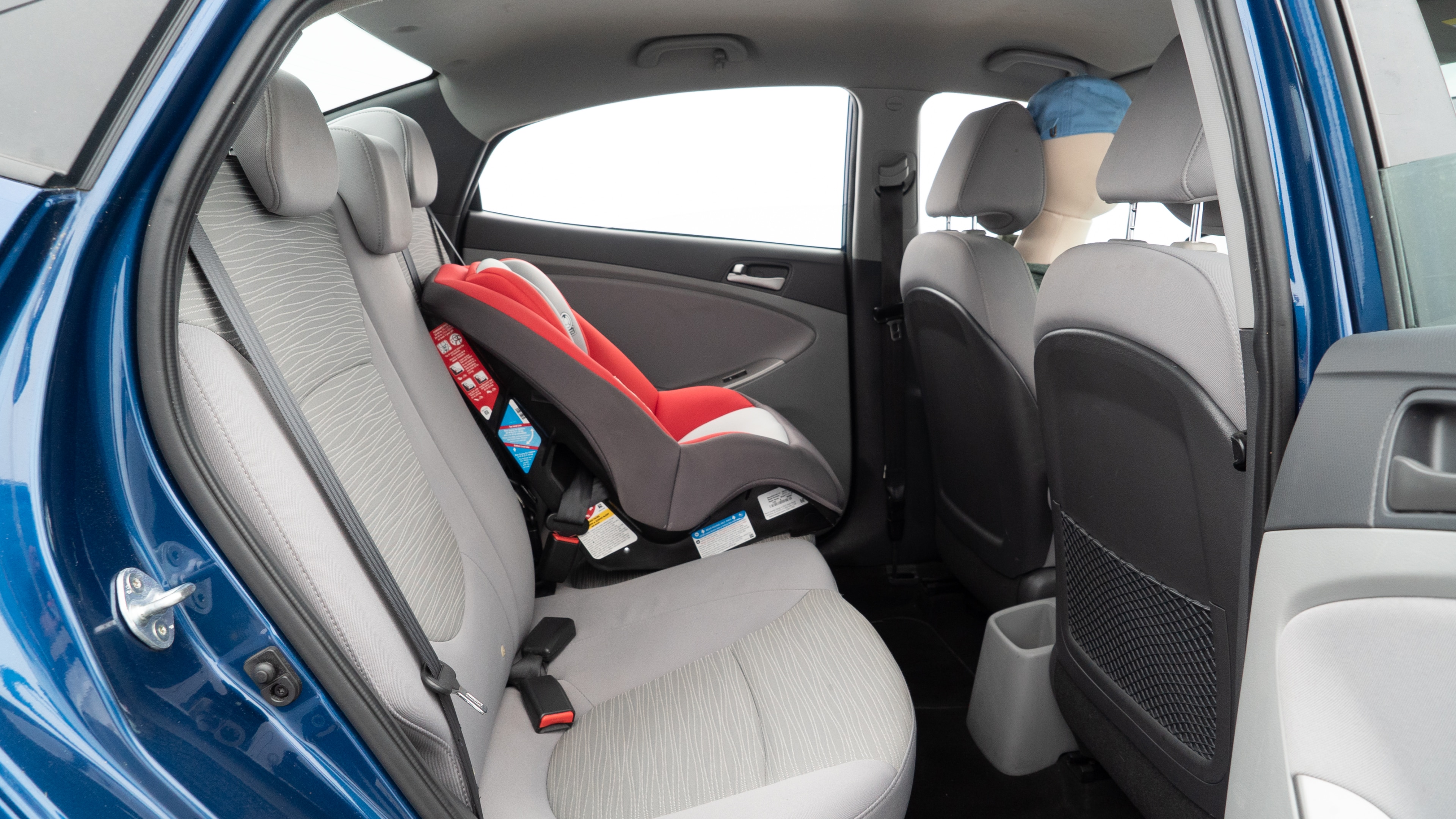 A series of second-row backseat photos is shown including one seating a baby seat and one seating a 6'1" mannequin.