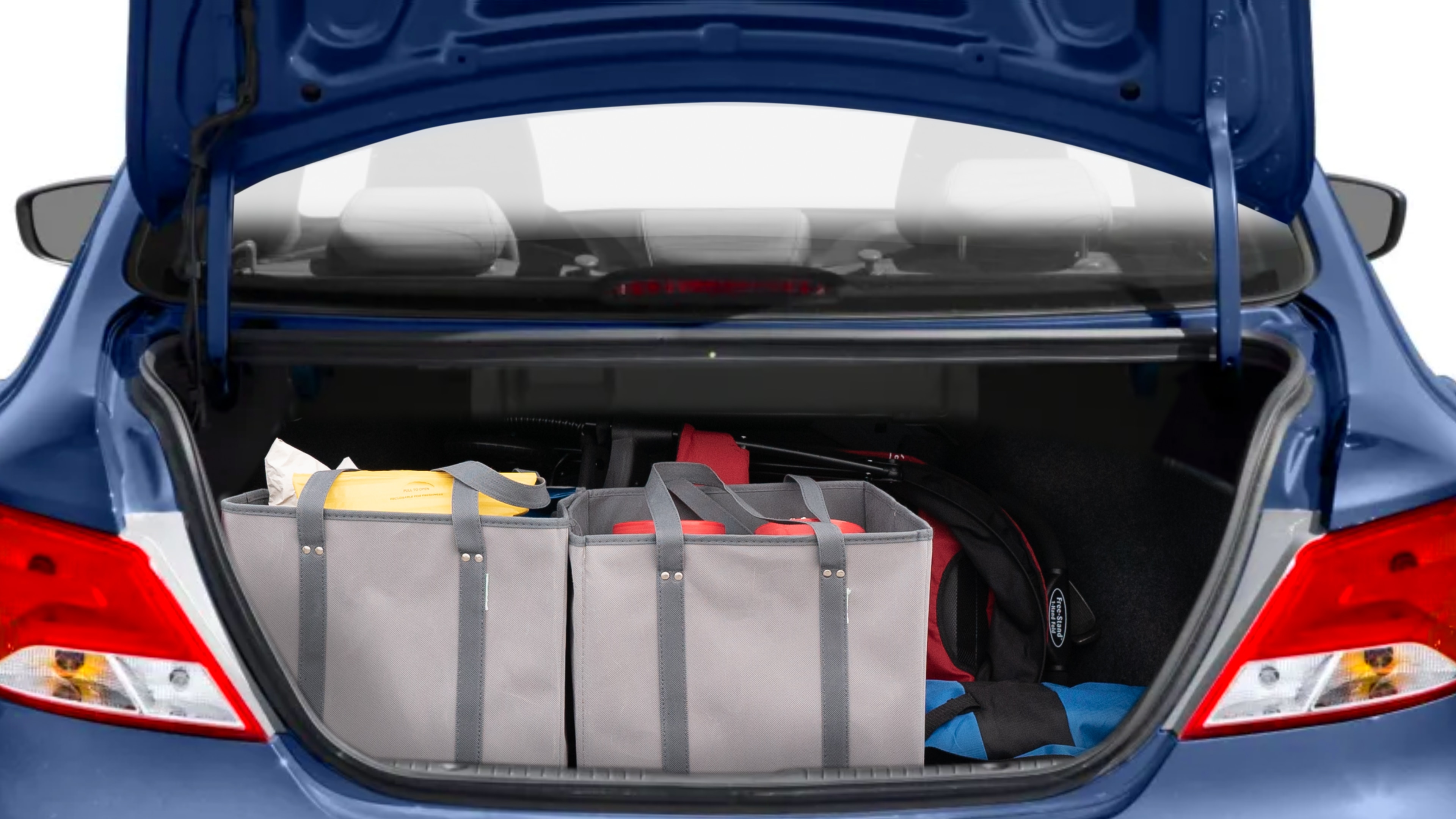 The trunk lid is open showing full view of the trunk. A baby stroller, three grocery carriers, two camping chairs in the carrying bag, and a set of golf clubs are placed inside.