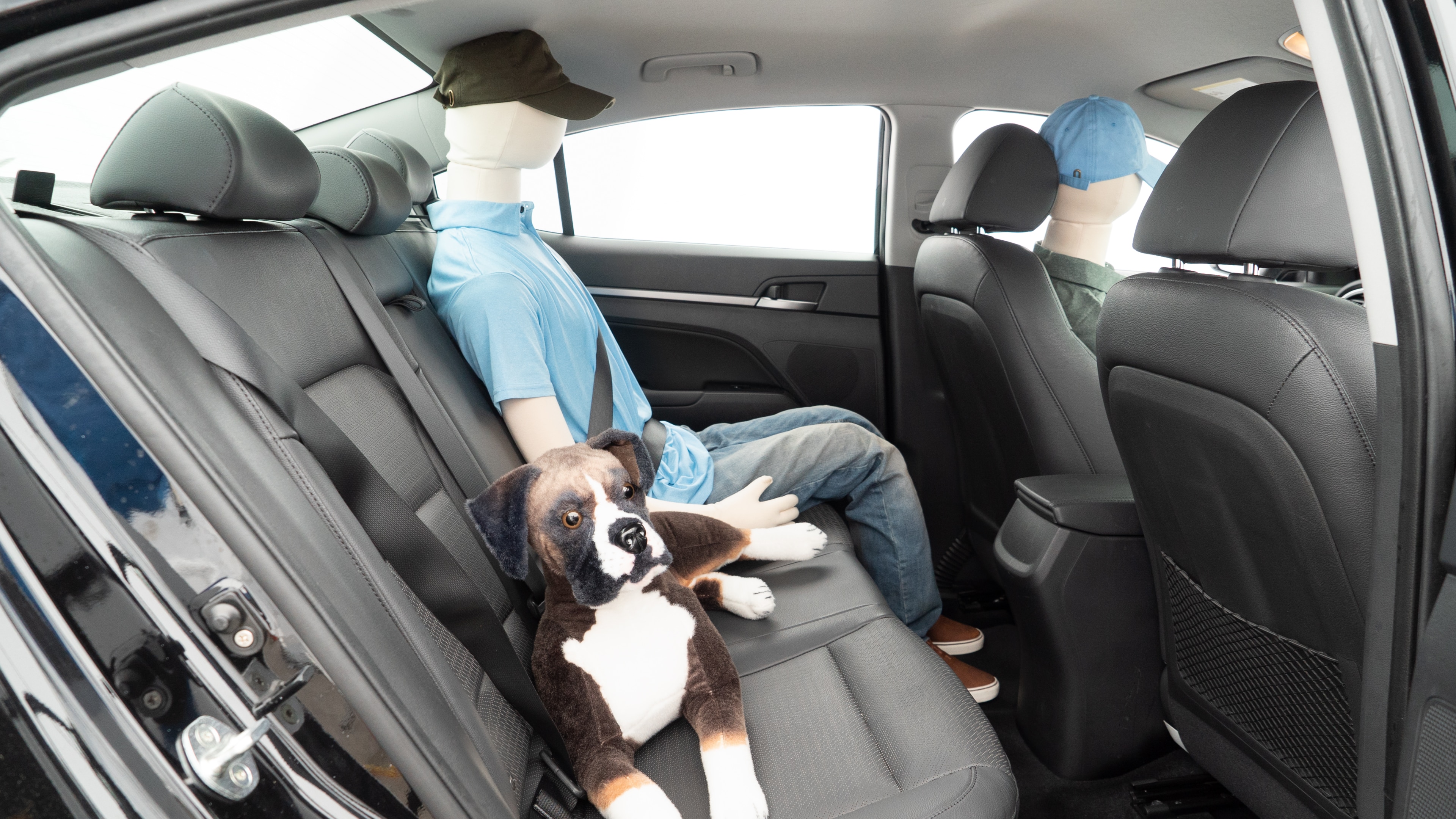 A series of second-row backseat photos is shown including one seating a baby seat and one seating a 6'1" mannequin.
