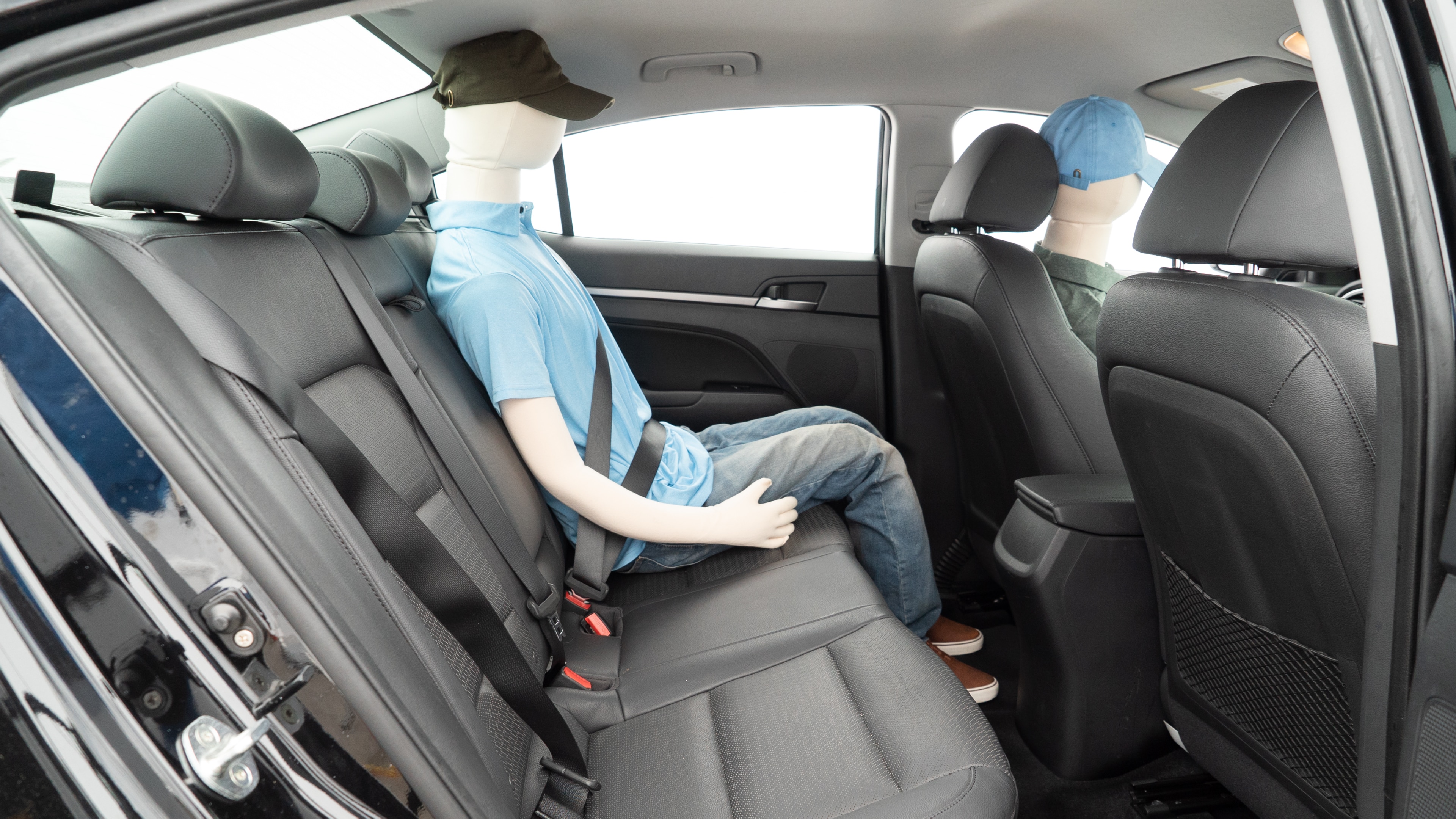 A series of second-row backseat photos is shown including one seating a baby seat and one seating a 6'1" mannequin.