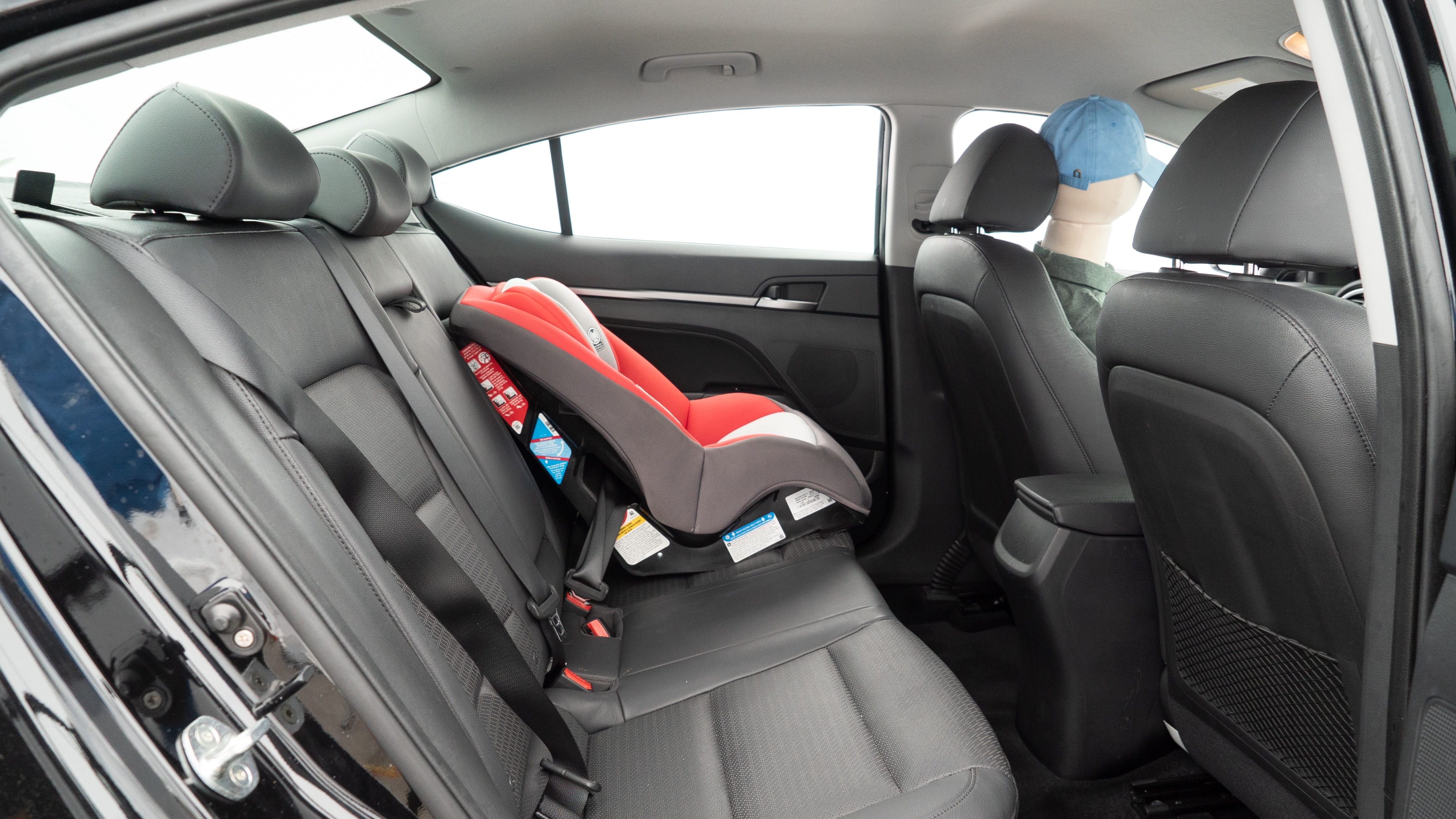 A series of second-row backseat photos is shown including one seating a baby seat and one seating a 6'1" mannequin.