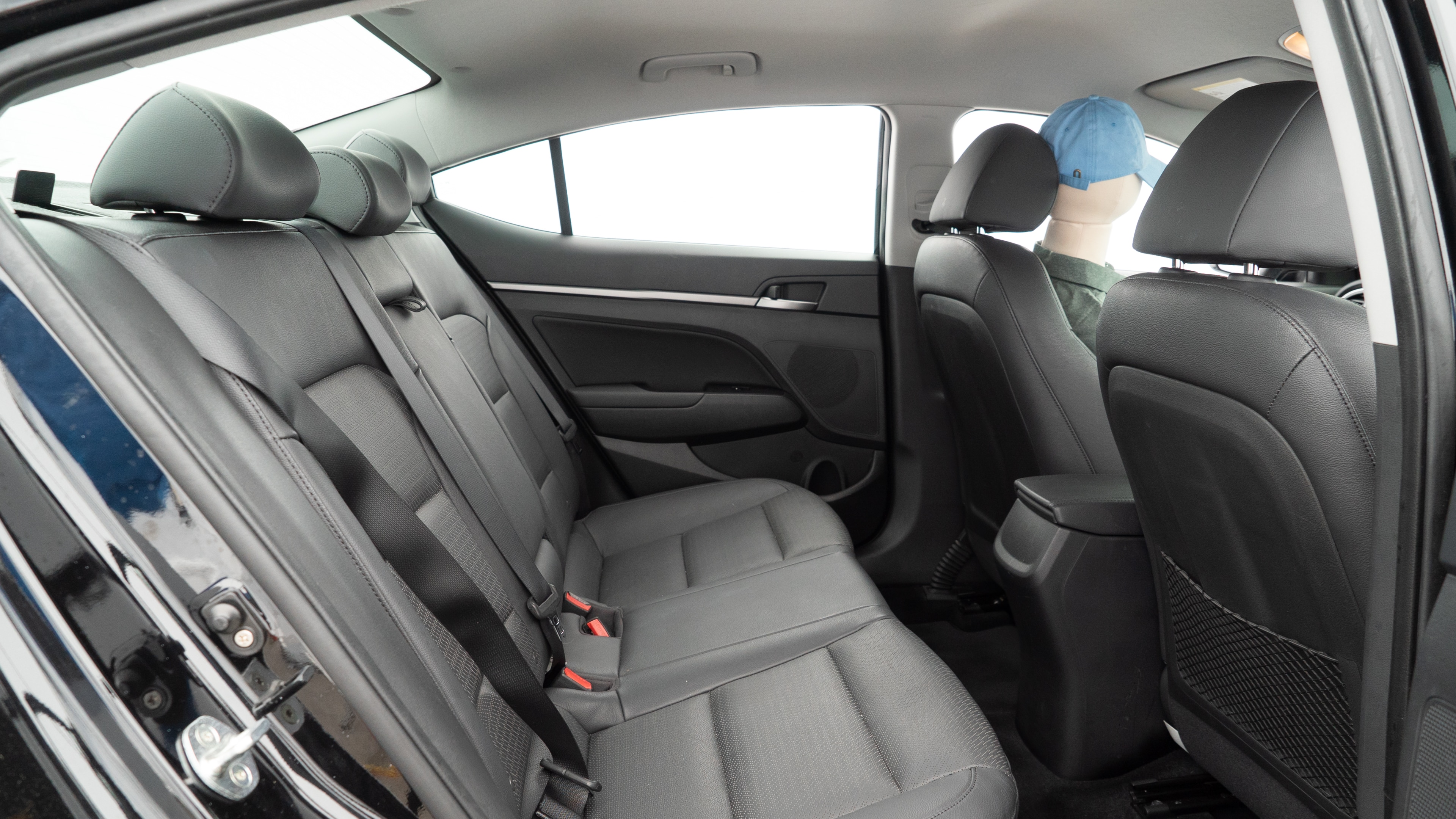 A series of second-row backseat photos is shown including one seating a baby seat and one seating a 6'1" mannequin.