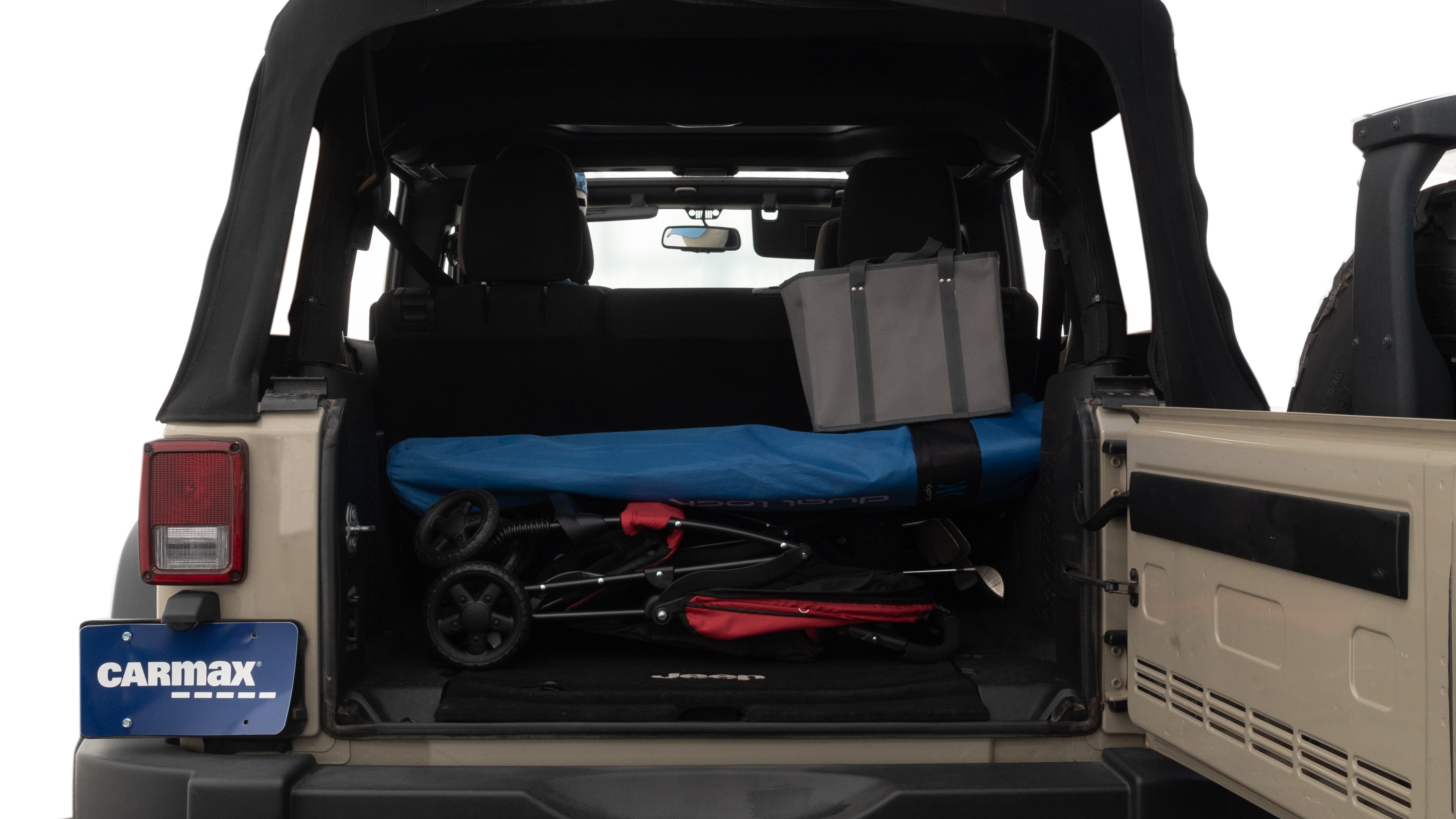 The trunk lid is open showing full view of the trunk. A baby stroller, three grocery carriers, two camping chairs in the carrying bag, and a set of golf clubs are placed inside.