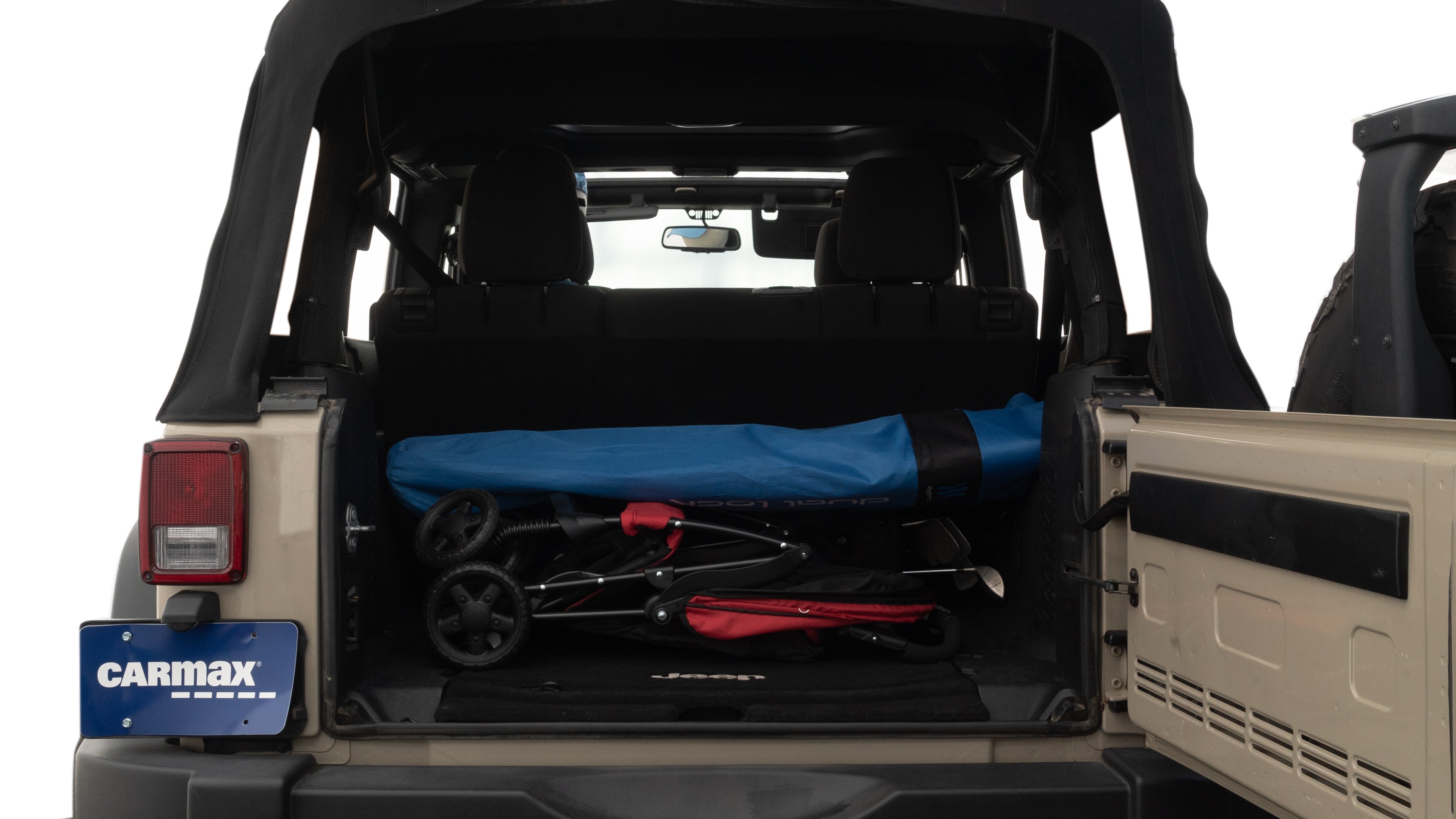 The trunk lid is open showing full view of the trunk. A baby stroller, three grocery carriers, two camping chairs in the carrying bag, and a set of golf clubs are placed inside.