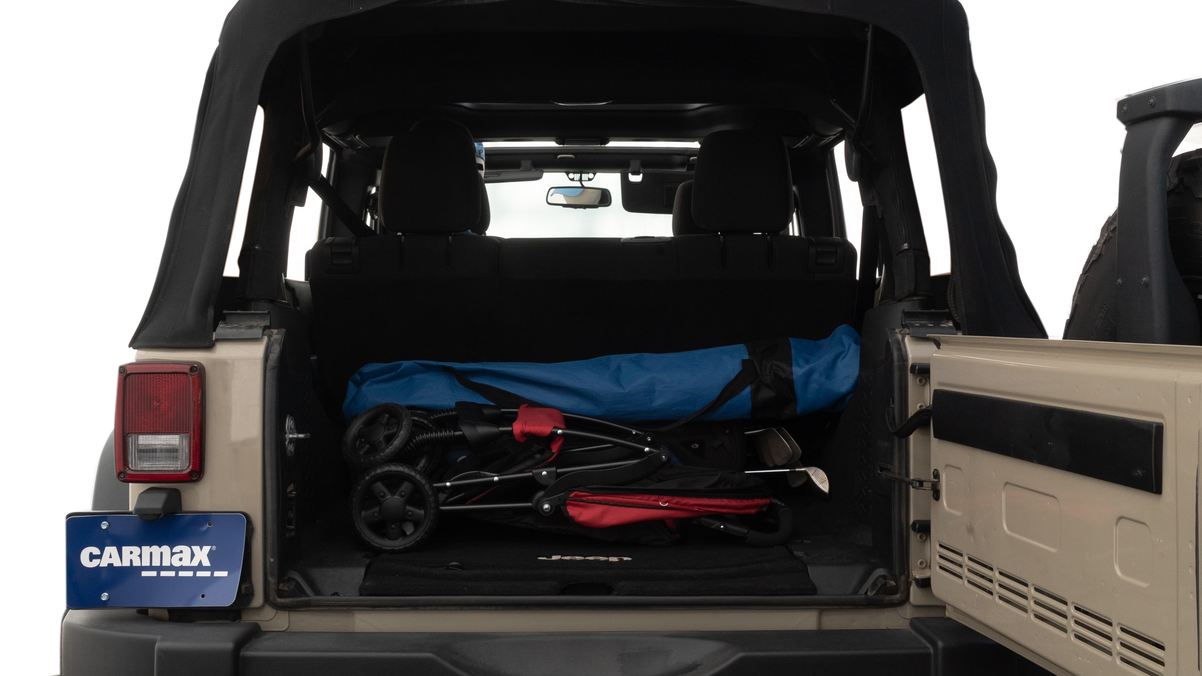 The trunk lid is open showing full view of the trunk. A baby stroller, three grocery carriers, two camping chairs in the carrying bag, and a set of golf clubs are placed inside.