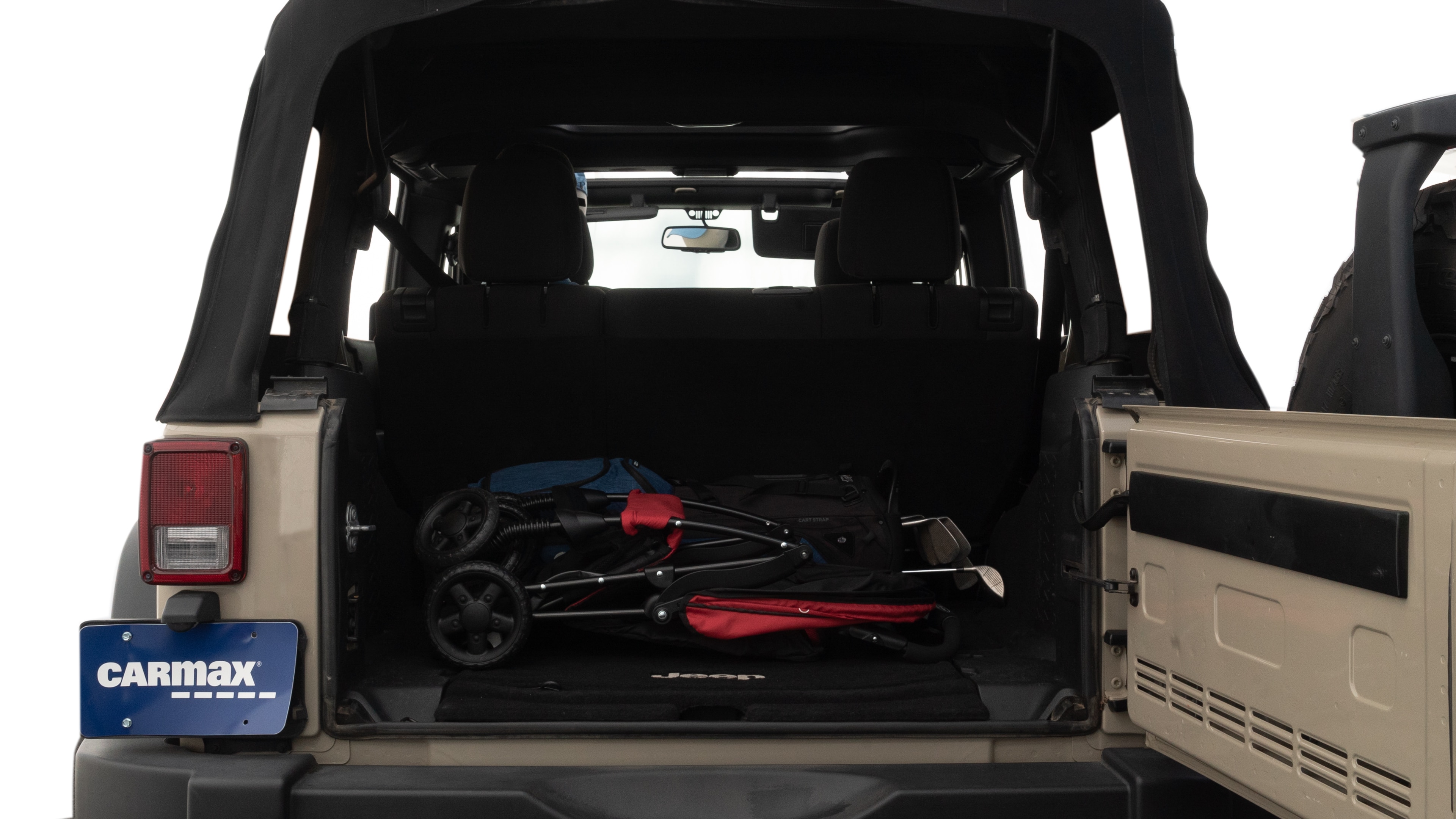 The trunk lid is open showing full view of the trunk. A baby stroller, three grocery carriers, two camping chairs in the carrying bag, and a set of golf clubs are placed inside.