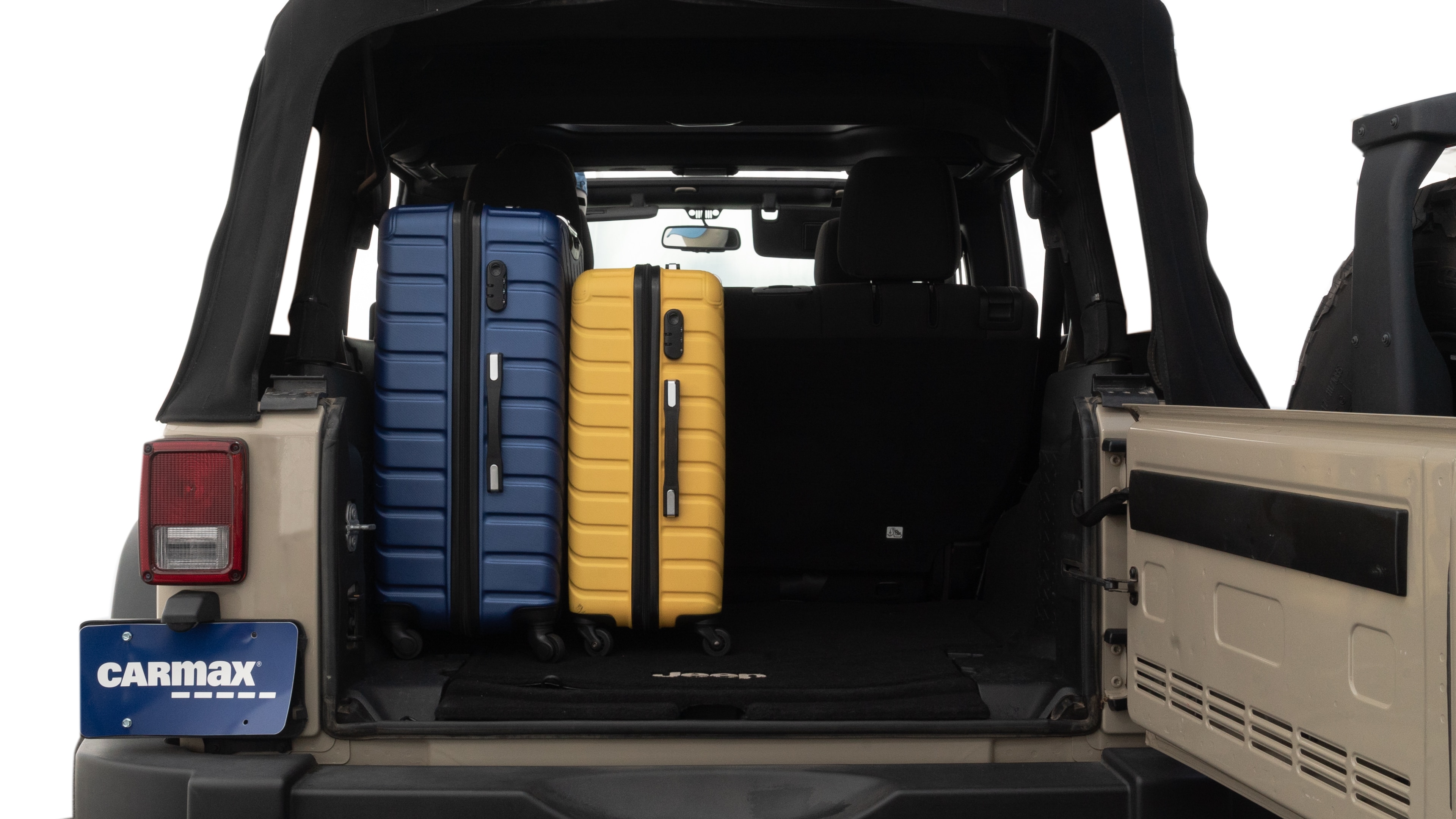 The trunk lid is open, showing full view of the trunk space. One large, two medium, and one small suitcases are placed inside.