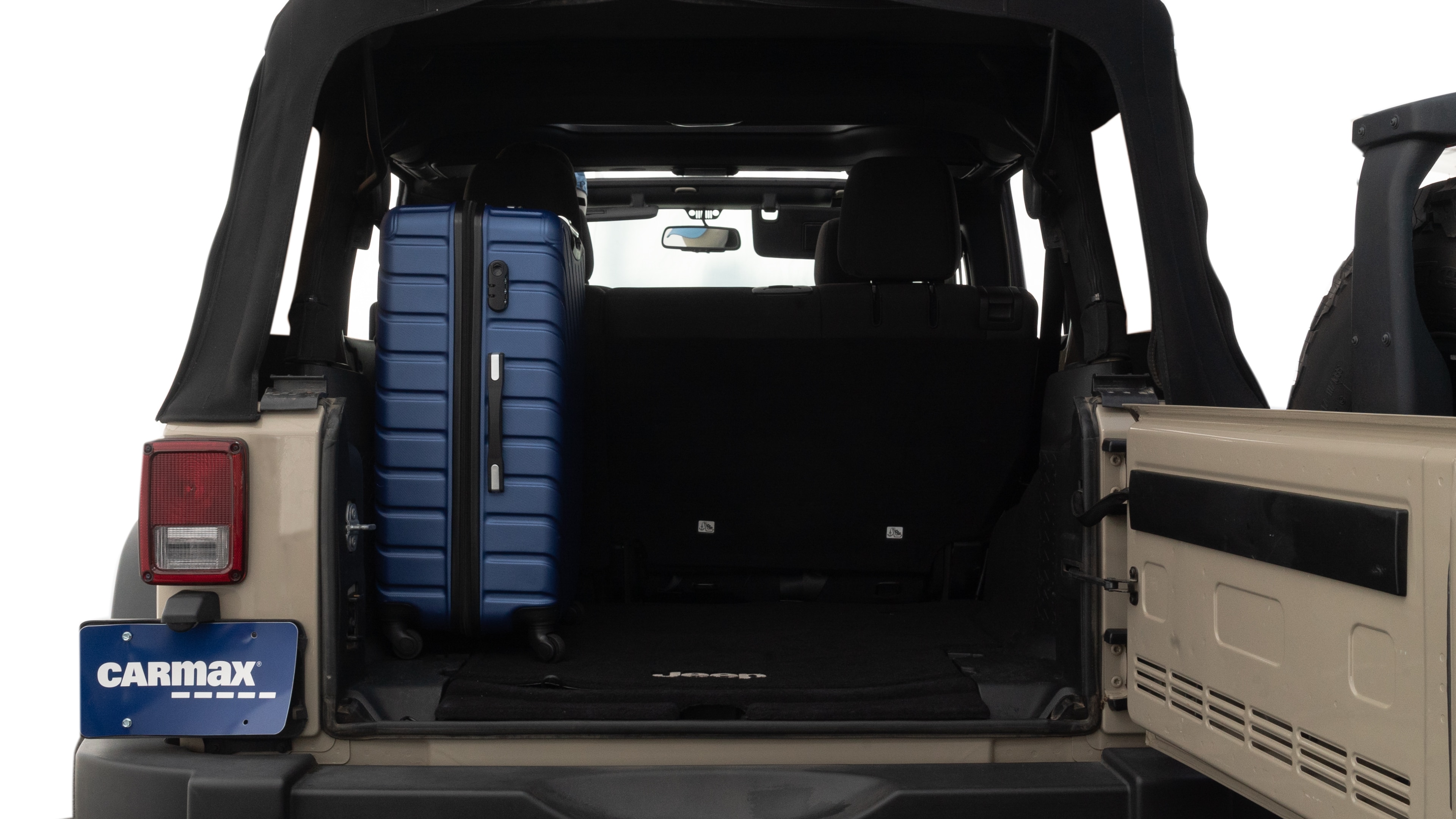 The trunk lid is open, showing full view of the trunk space. One large, two medium, and one small suitcases are placed inside.
