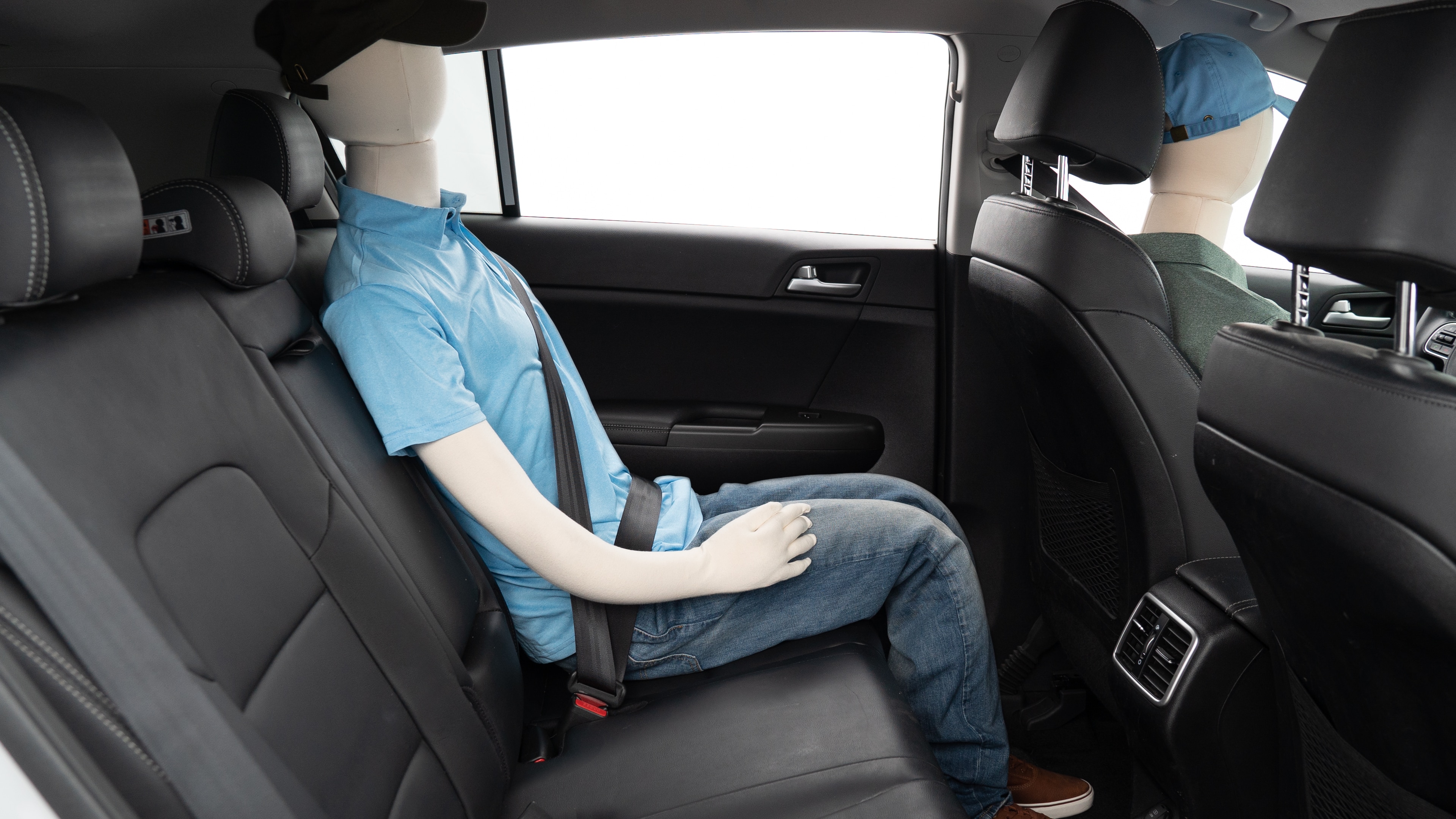 A series of second-row backseat photos is shown including one seating a baby seat, a dog and one seating a 6'1" mannequin.