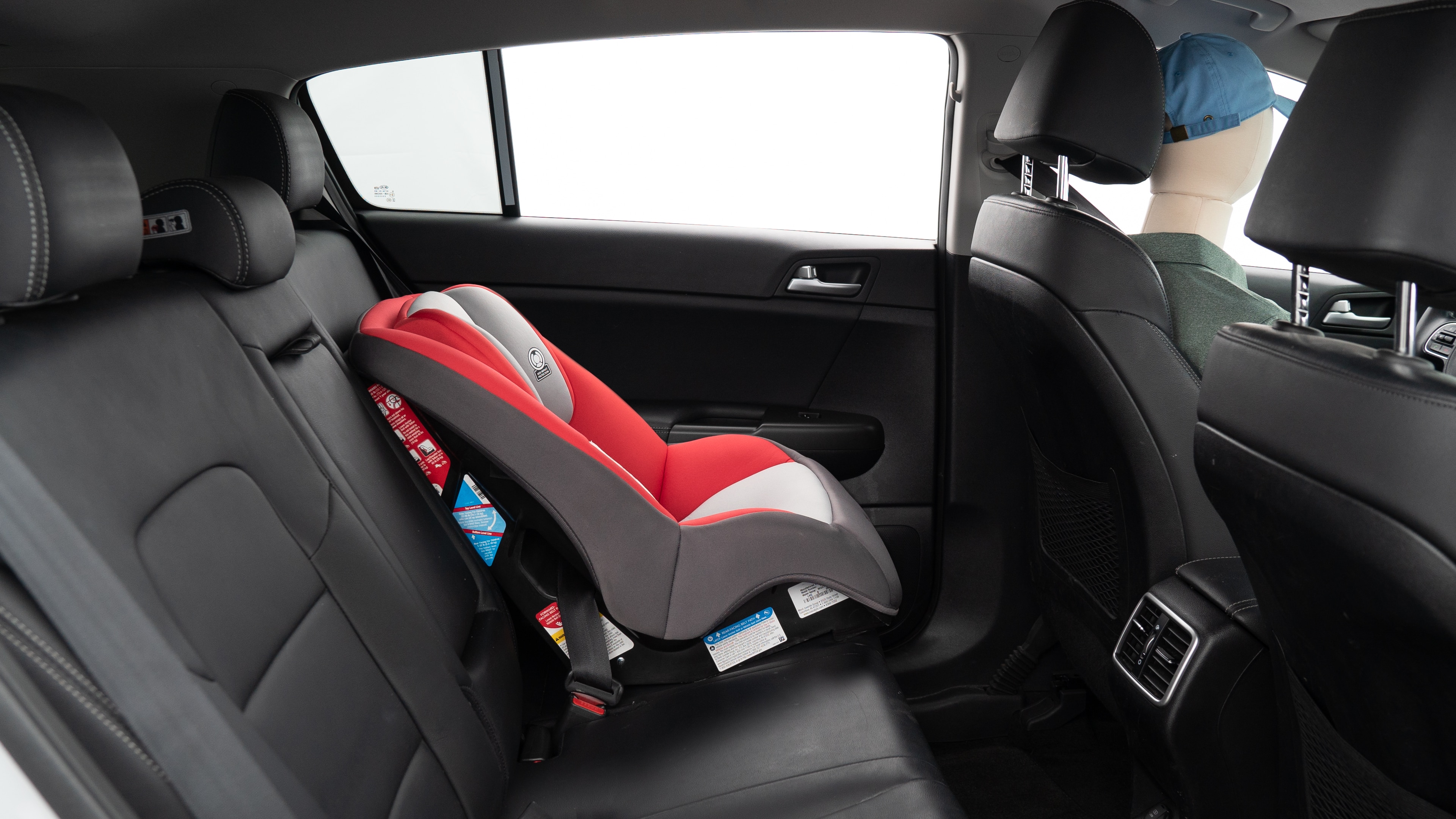 A series of second-row backseat photos is shown including one seating a baby seat, a dog and one seating a 6'1" mannequin.