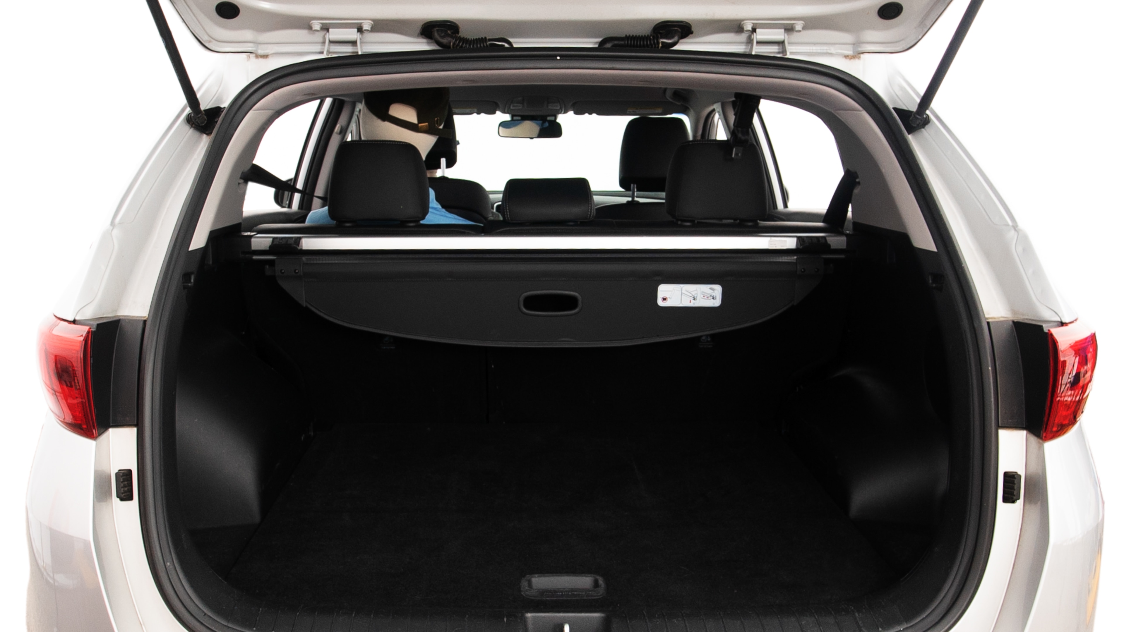 The trunk lid is open showing full view of the trunk. A baby stroller, three grocery carriers, two camping chairs in the carrying bag, and a set of golf clubs are placed inside.