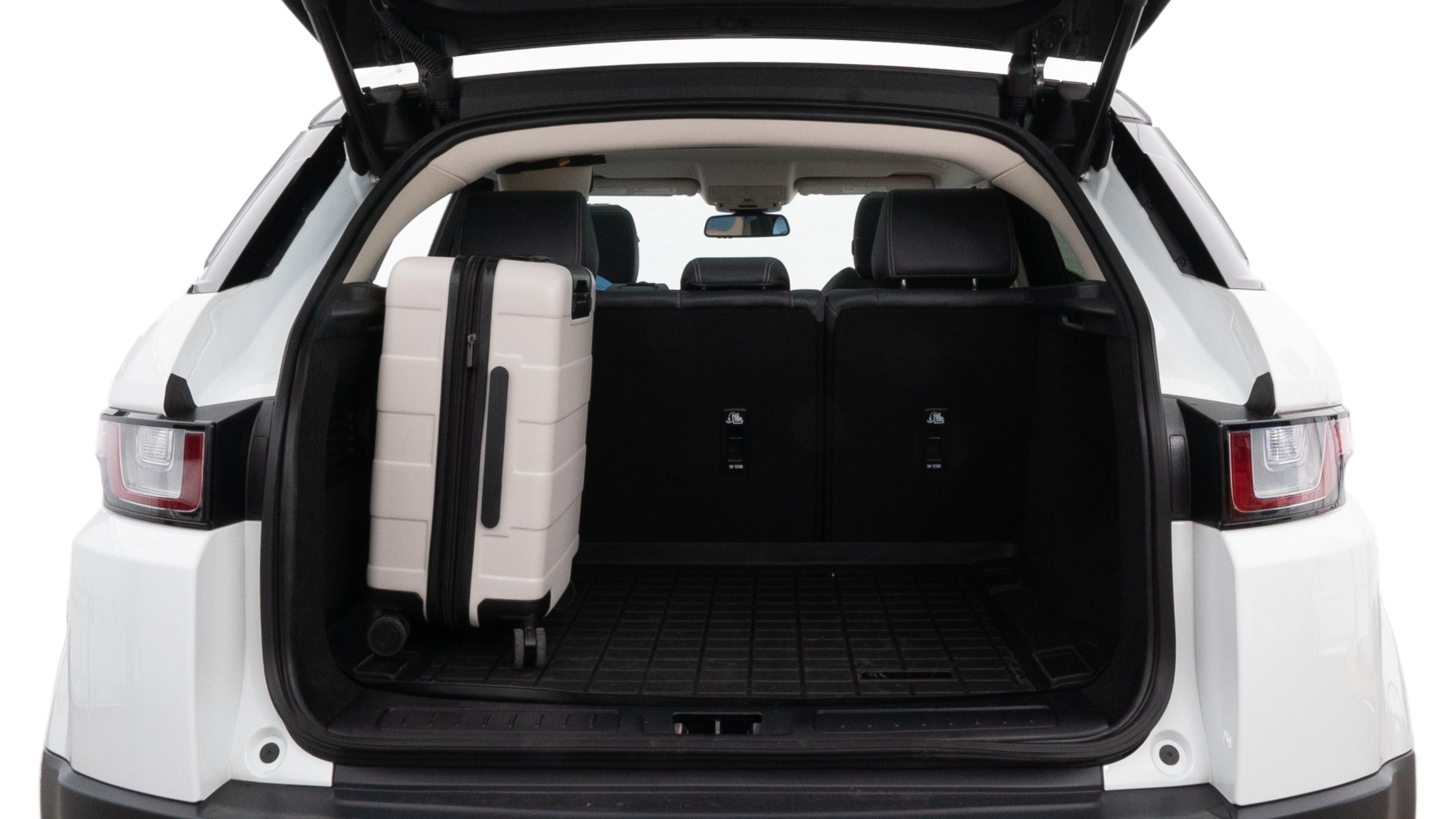 The trunk lid is open, showing full view of the trunk space. Two medium and two small suitcases are placed inside.