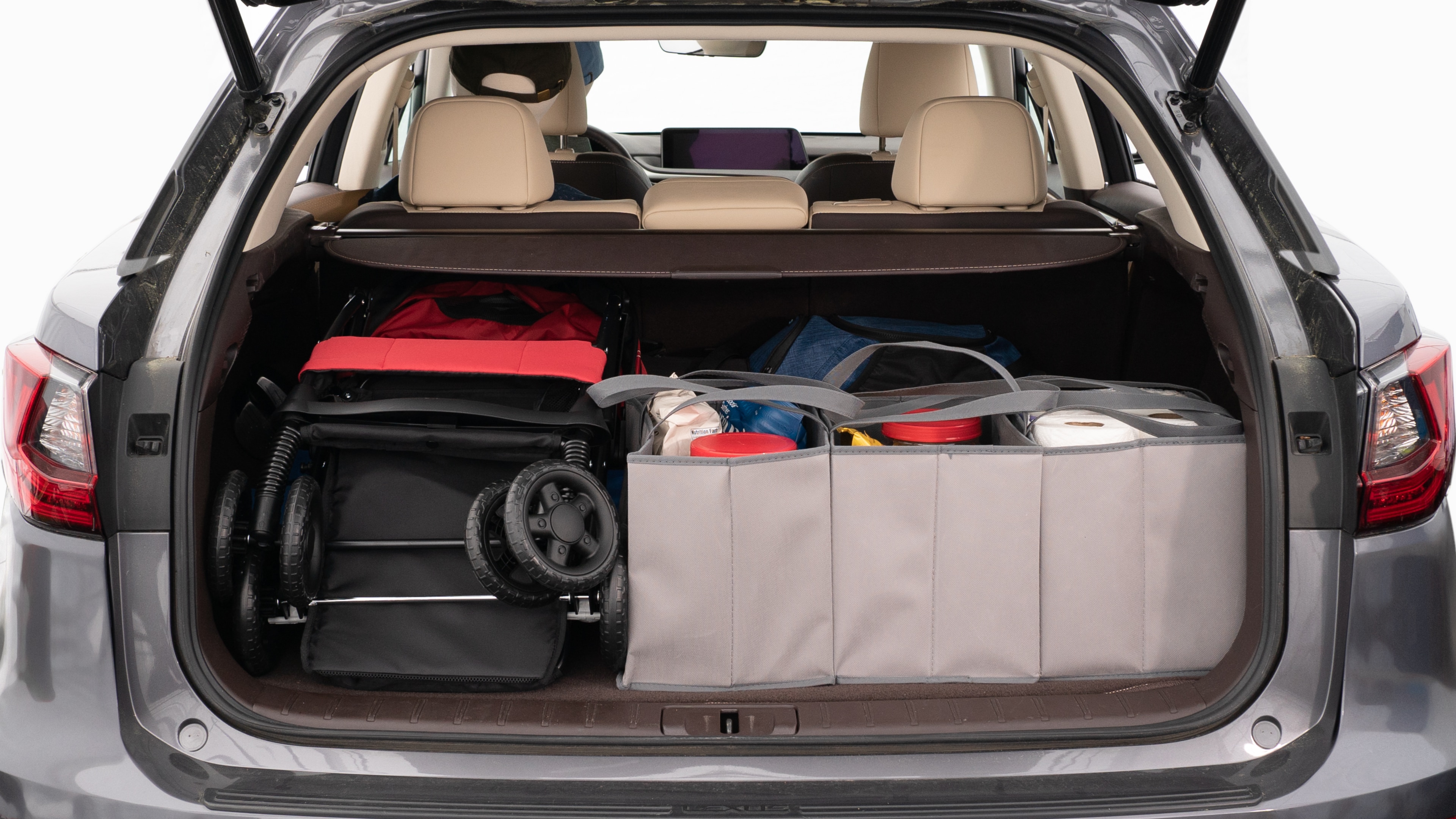 The trunk lid is open showing full view of the trunk. A baby stroller, three grocery carriers, two camping chairs in the carrying bag, and a set of golf clubs are placed inside.