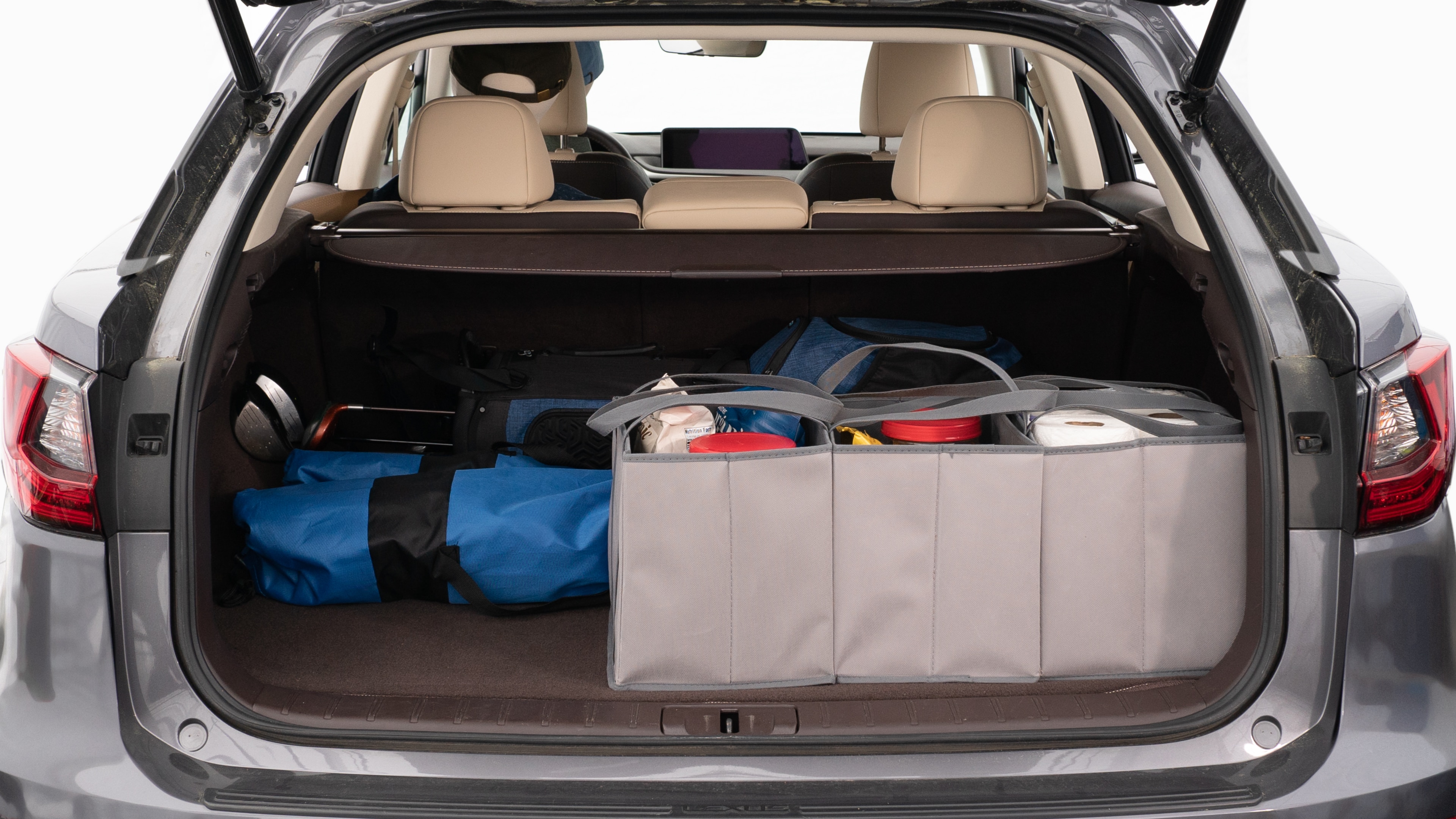 The trunk lid is open showing full view of the trunk. A baby stroller, three grocery carriers, two camping chairs in the carrying bag, and a set of golf clubs are placed inside.