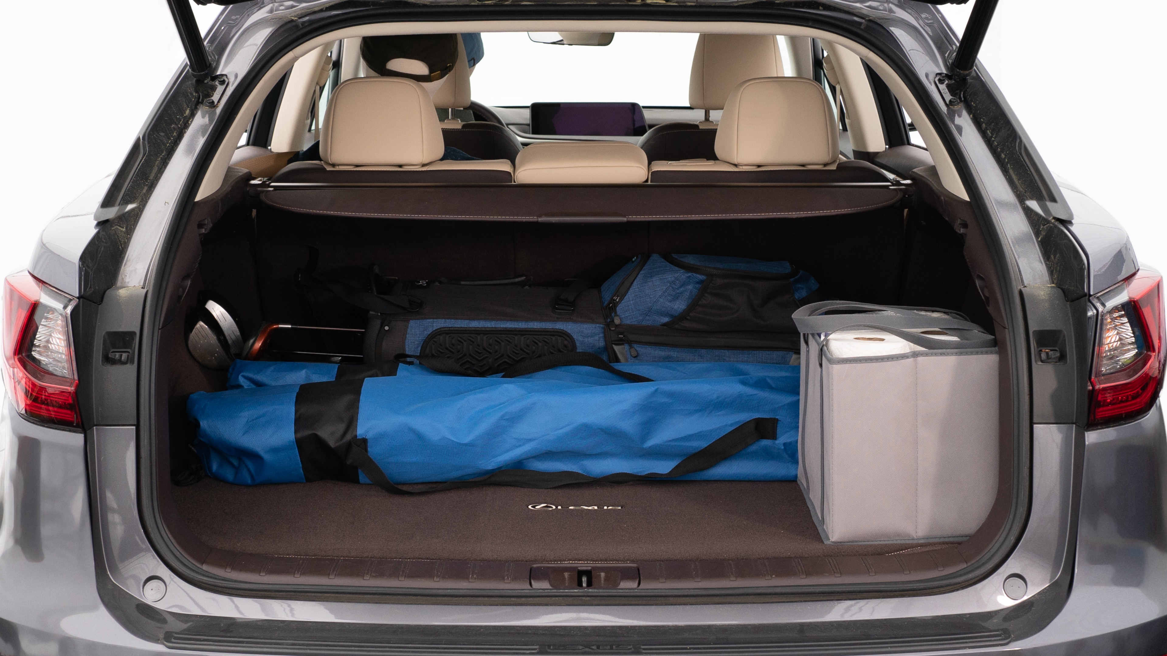 The trunk lid is open showing full view of the trunk. A baby stroller, three grocery carriers, two camping chairs in the carrying bag, and a set of golf clubs are placed inside.