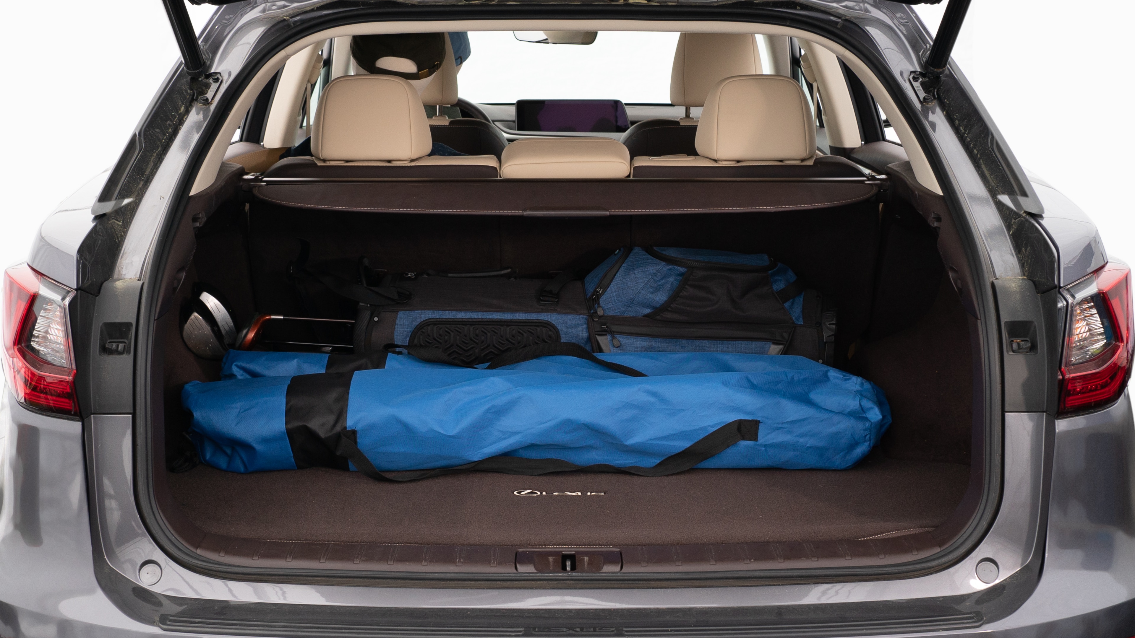The trunk lid is open showing full view of the trunk. A baby stroller, three grocery carriers, two camping chairs in the carrying bag, and a set of golf clubs are placed inside.