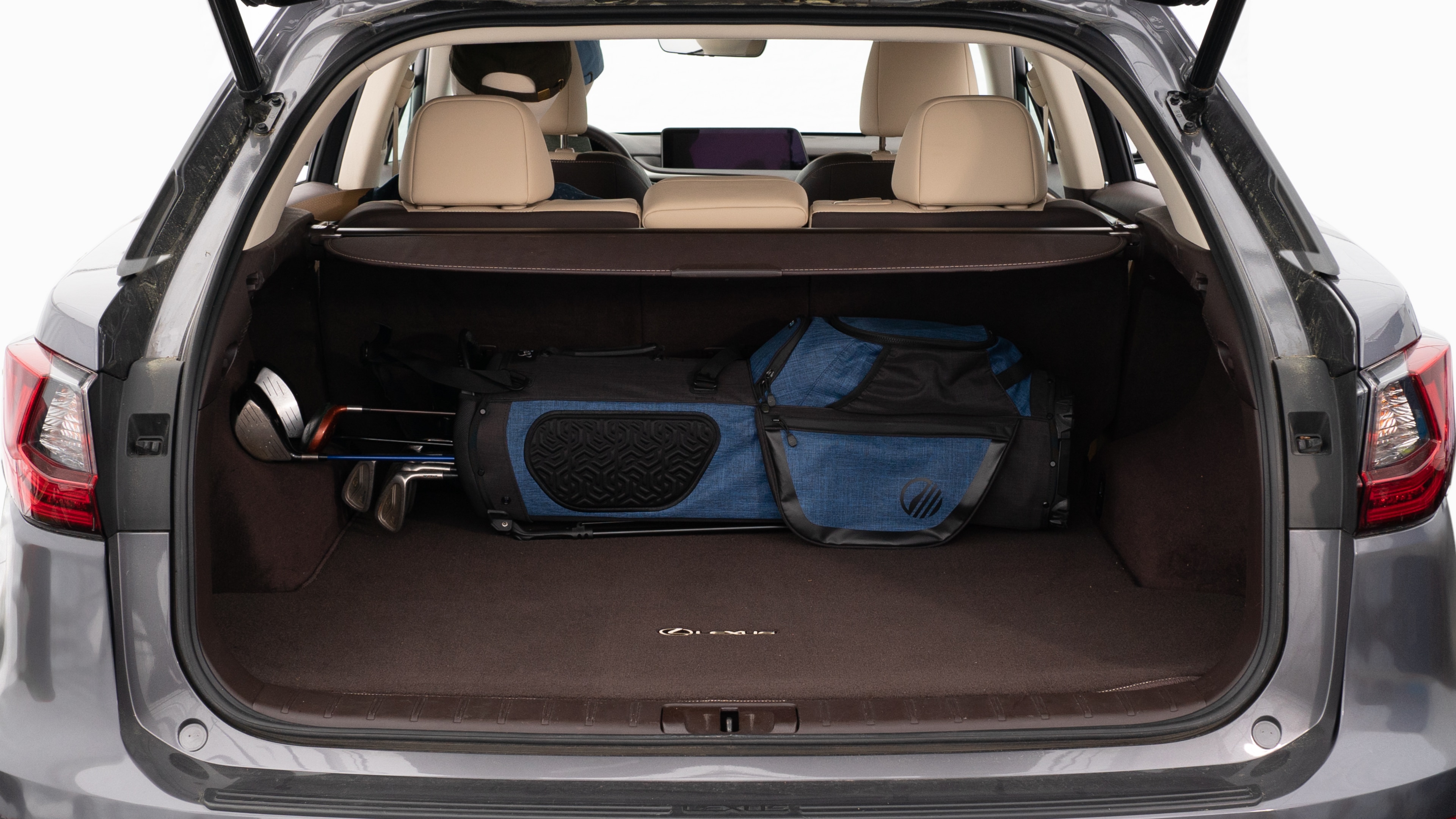 The trunk lid is open showing full view of the trunk. A baby stroller, three grocery carriers, two camping chairs in the carrying bag, and a set of golf clubs are placed inside.