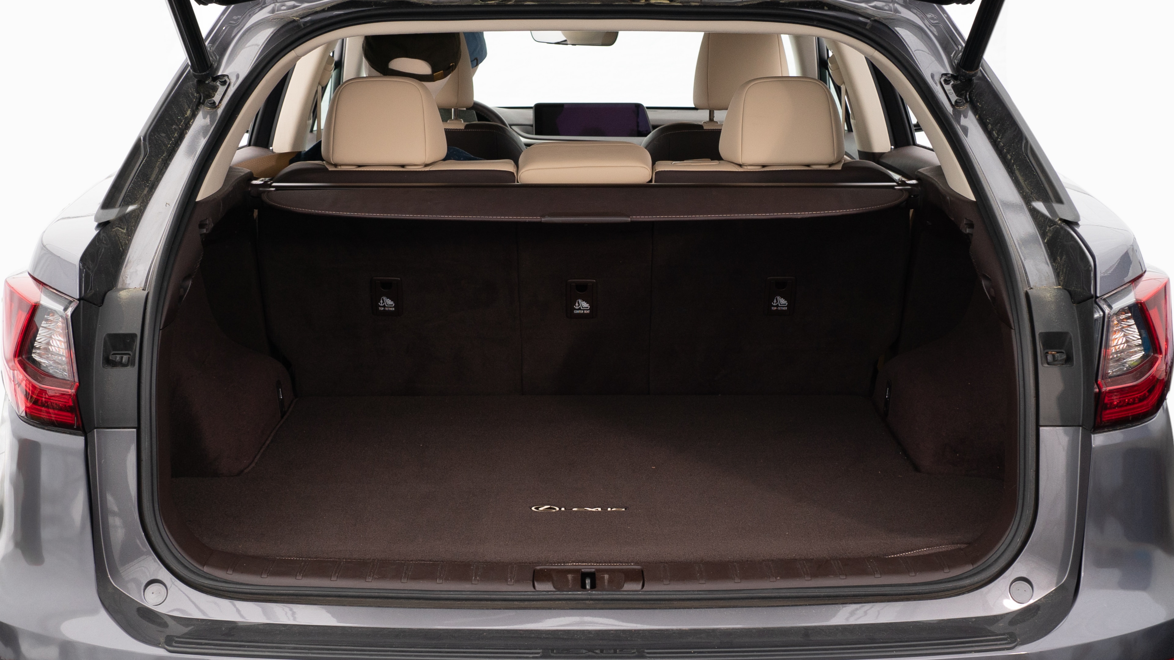 The trunk lid is open showing full view of the trunk. A baby stroller, three grocery carriers, two camping chairs in the carrying bag, and a set of golf clubs are placed inside.