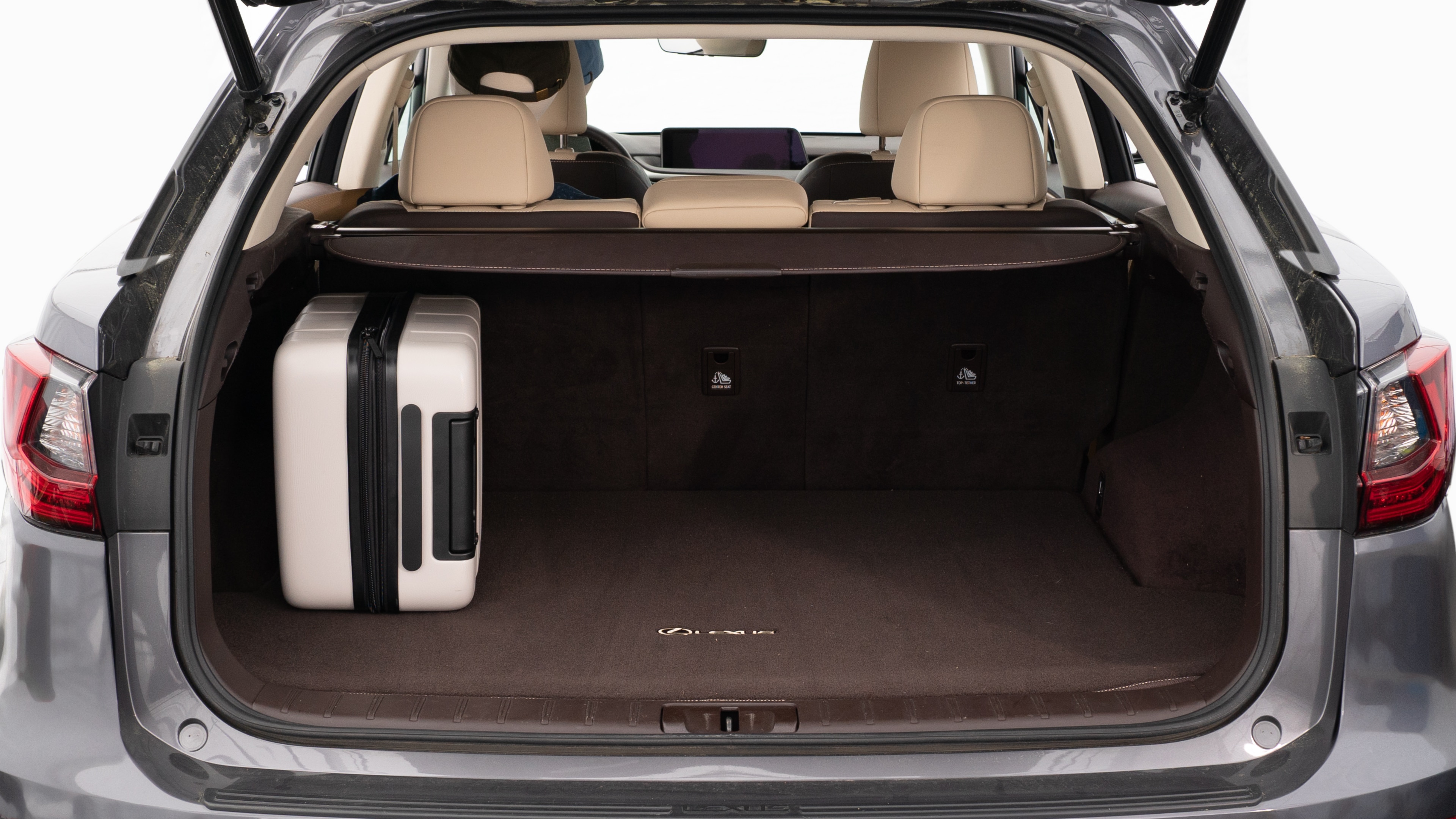The trunk lid is open, showing a full view of the trunk space. Two large and two small suitcases are are placed inside.