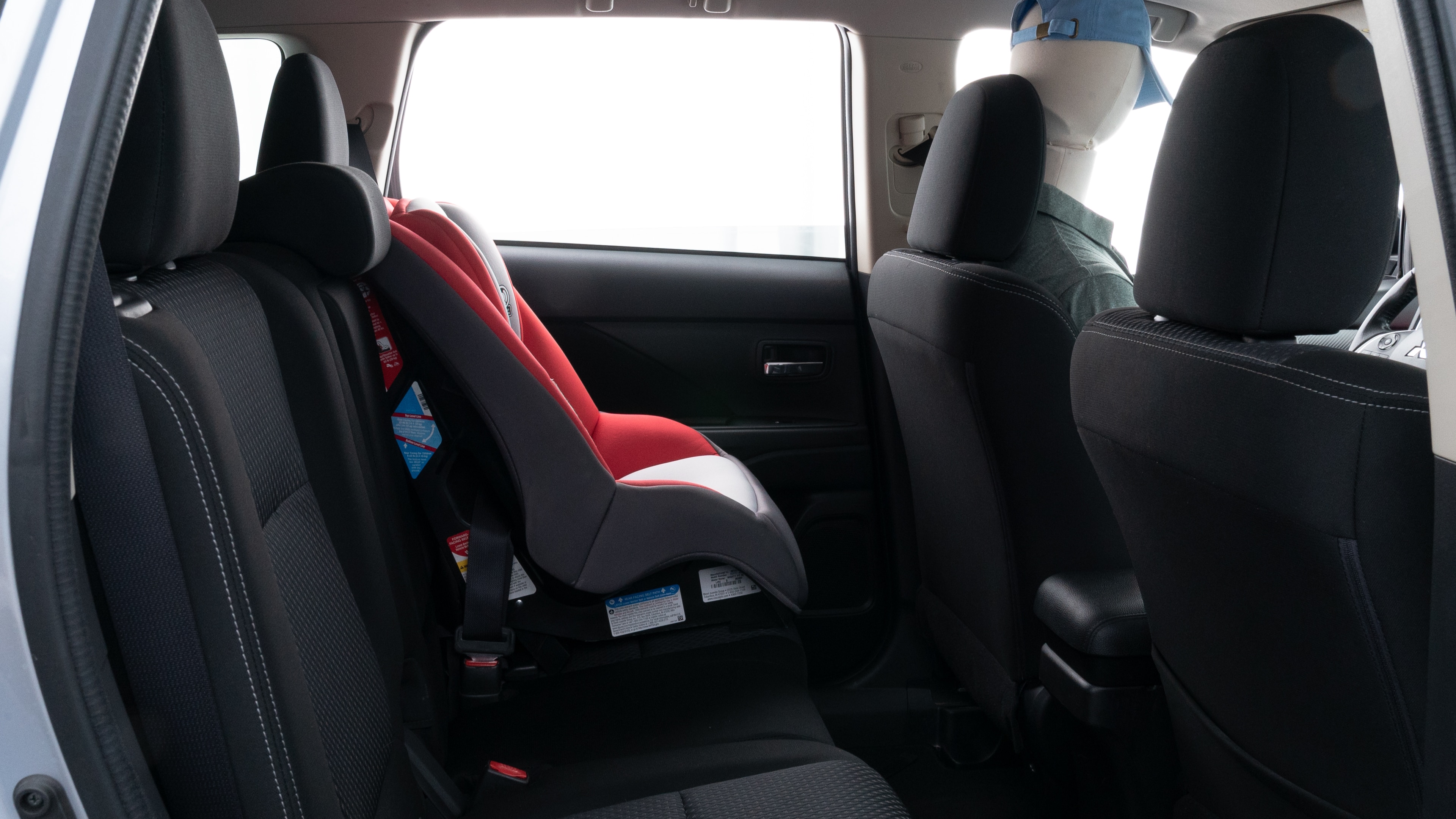 A series of second-row backseat photos is shown including one seating a baby seat and one seating a 6'1" mannequin.