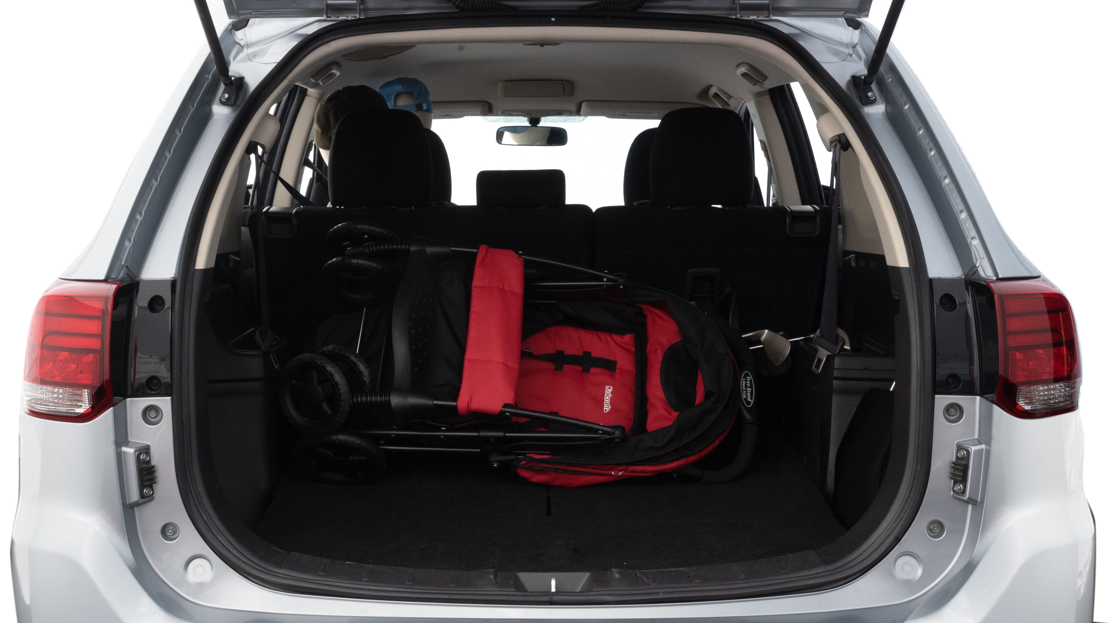 The trunk lid is open showing full view of the trunk. A baby stroller, three grocery carriers, two camping chairs in the carrying bag, and a set of golf clubs are placed inside.