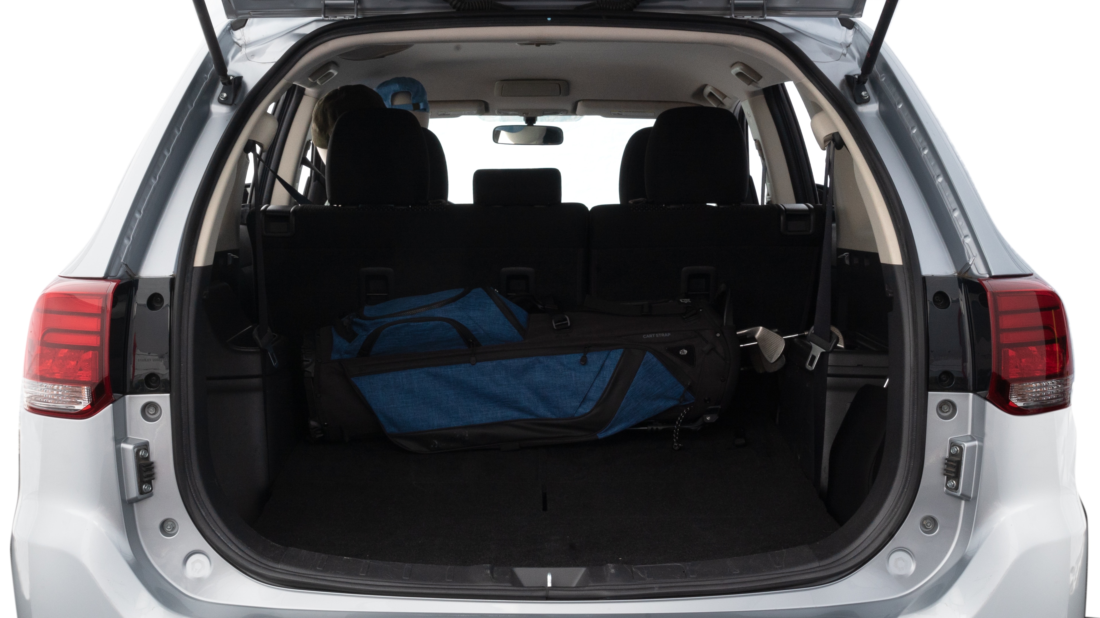 The trunk lid is open showing full view of the trunk. A baby stroller, three grocery carriers, two camping chairs in the carrying bag, and a set of golf clubs are placed inside.