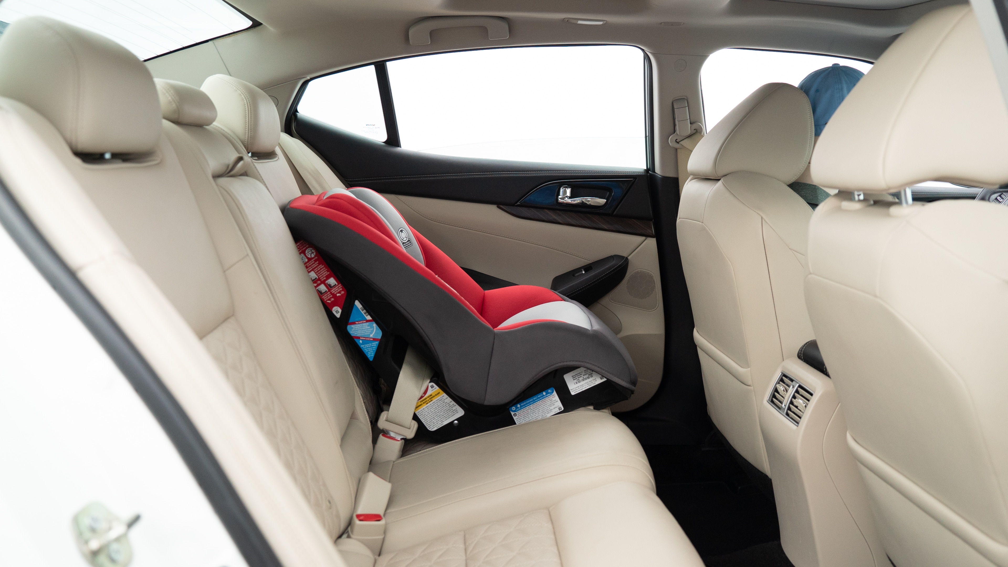 A series of second-row backseat photos is shown including one seating a baby seat, a dog and one seating a 6'1" mannequin.