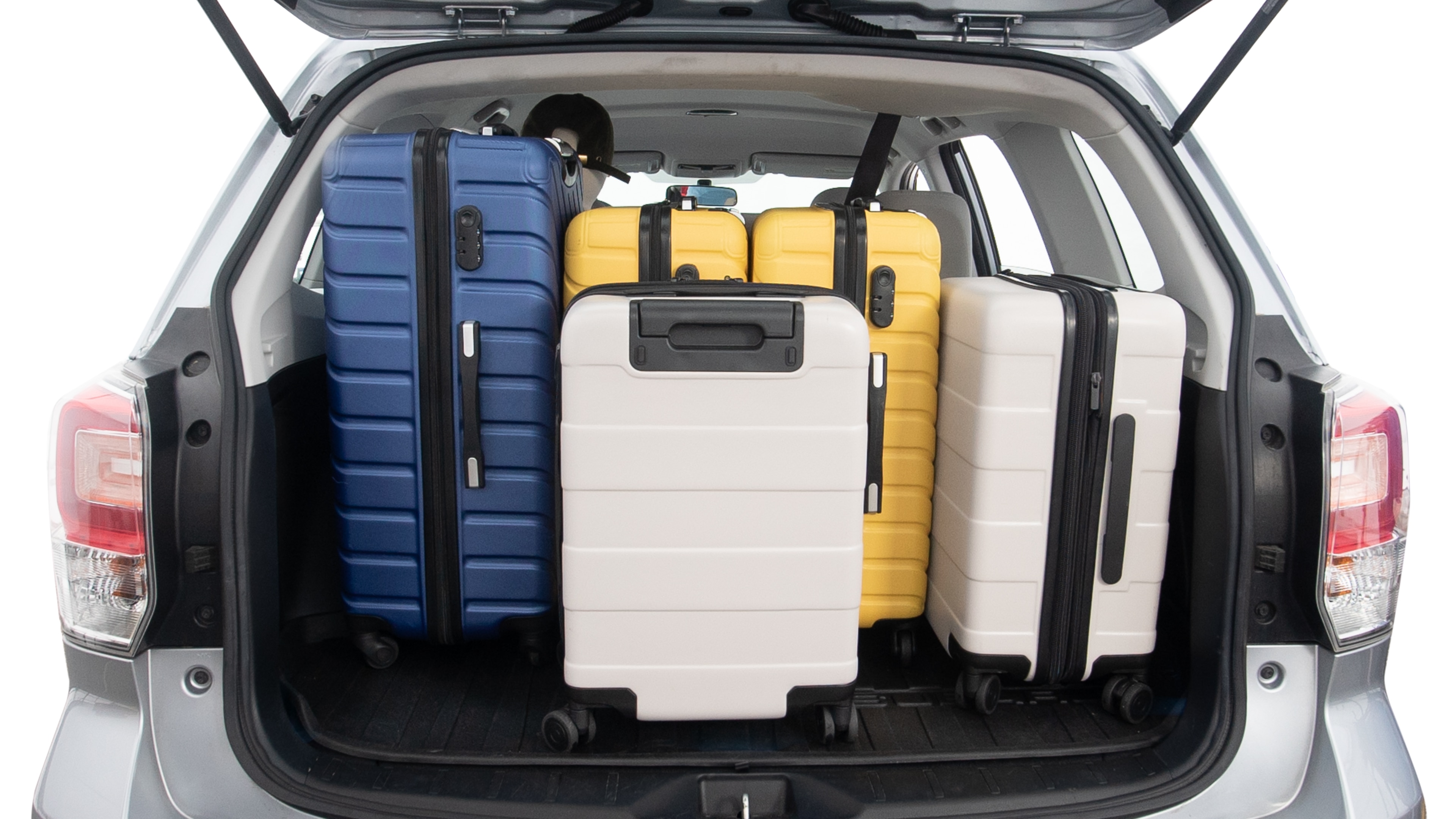 The trunk lid is open, showing full view of the trunk space. One extra large suitcase, two large suitcases and two small suitcases are placed inside.