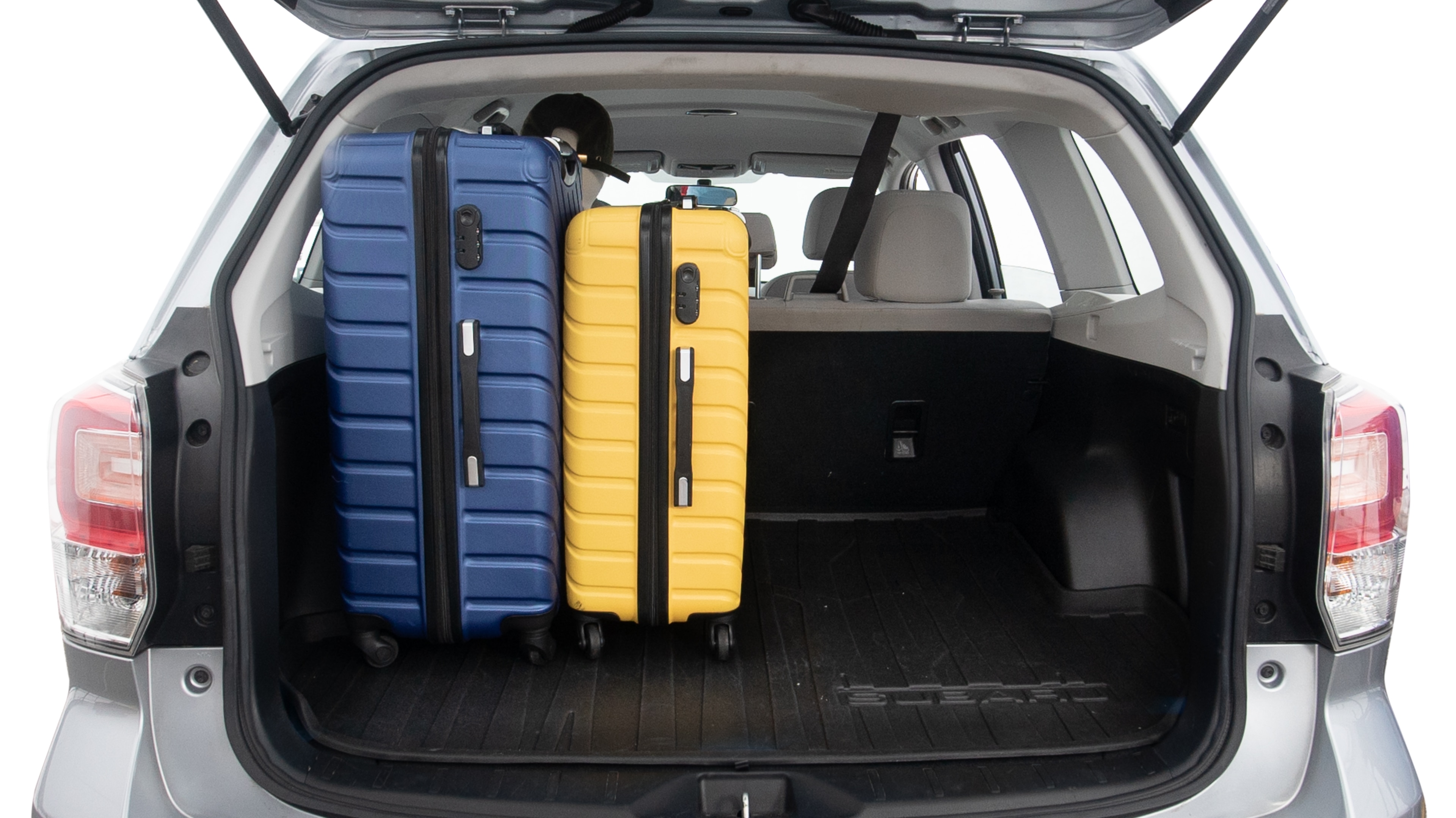 The trunk lid is open, showing full view of the trunk space. One extra large suitcase, two large suitcases and two small suitcases are placed inside.