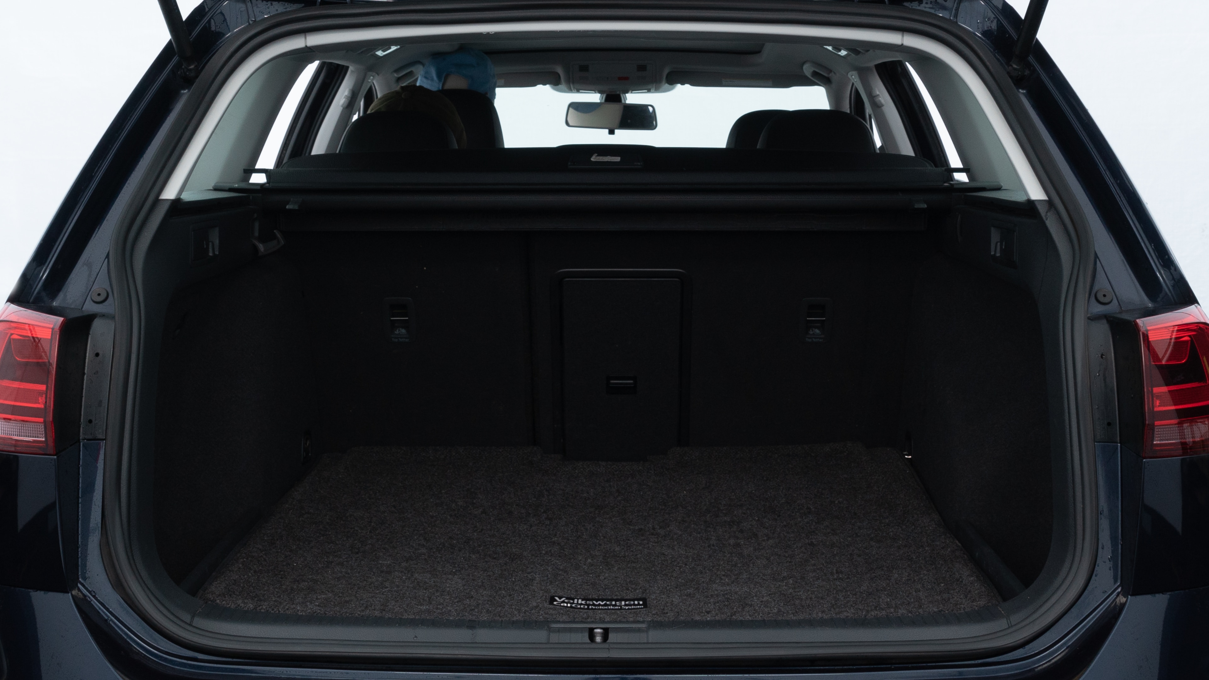 The trunk lid is open showing full view of the trunk. A baby stroller, three grocery carriers, two camping chairs in the carrying bag, and a set of golf clubs are placed inside.