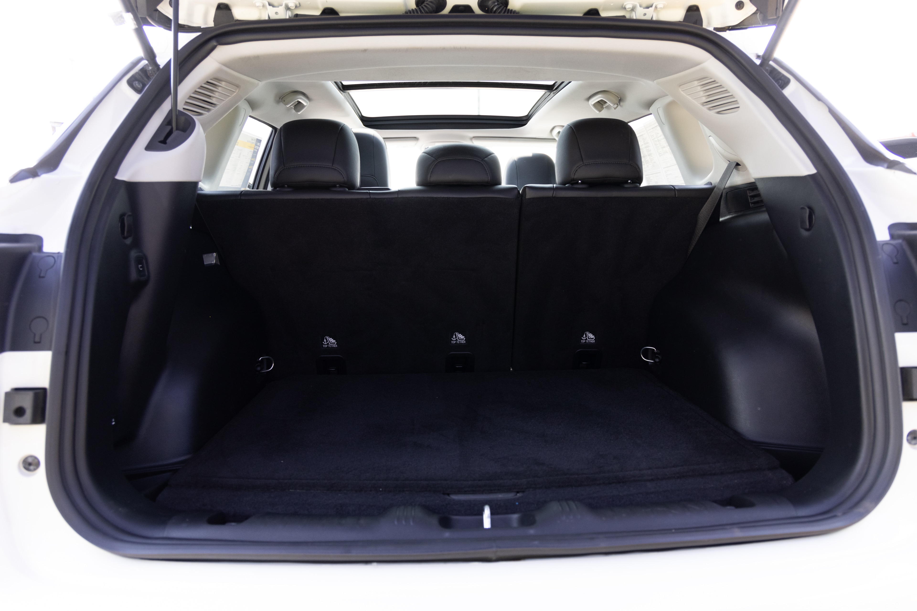 The cargo area is open giving a full view of the cargo area. A baby stroller, four grocery carriers, a yoga mat, and a set of golf clubs are placed inside.