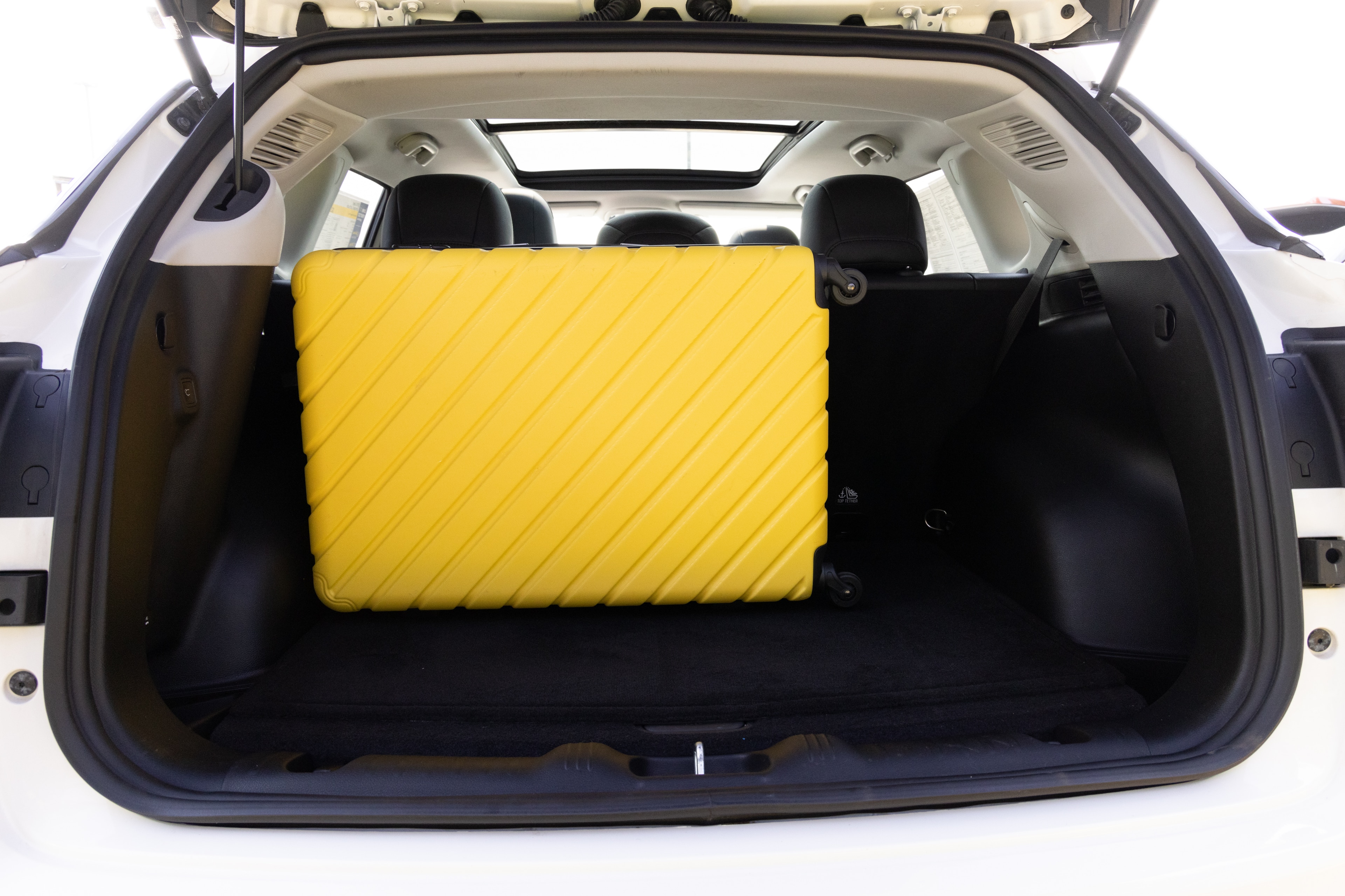 The cargo area is open giving a full view of the cargo area. Two large and two small suitcases are placed on their sides.