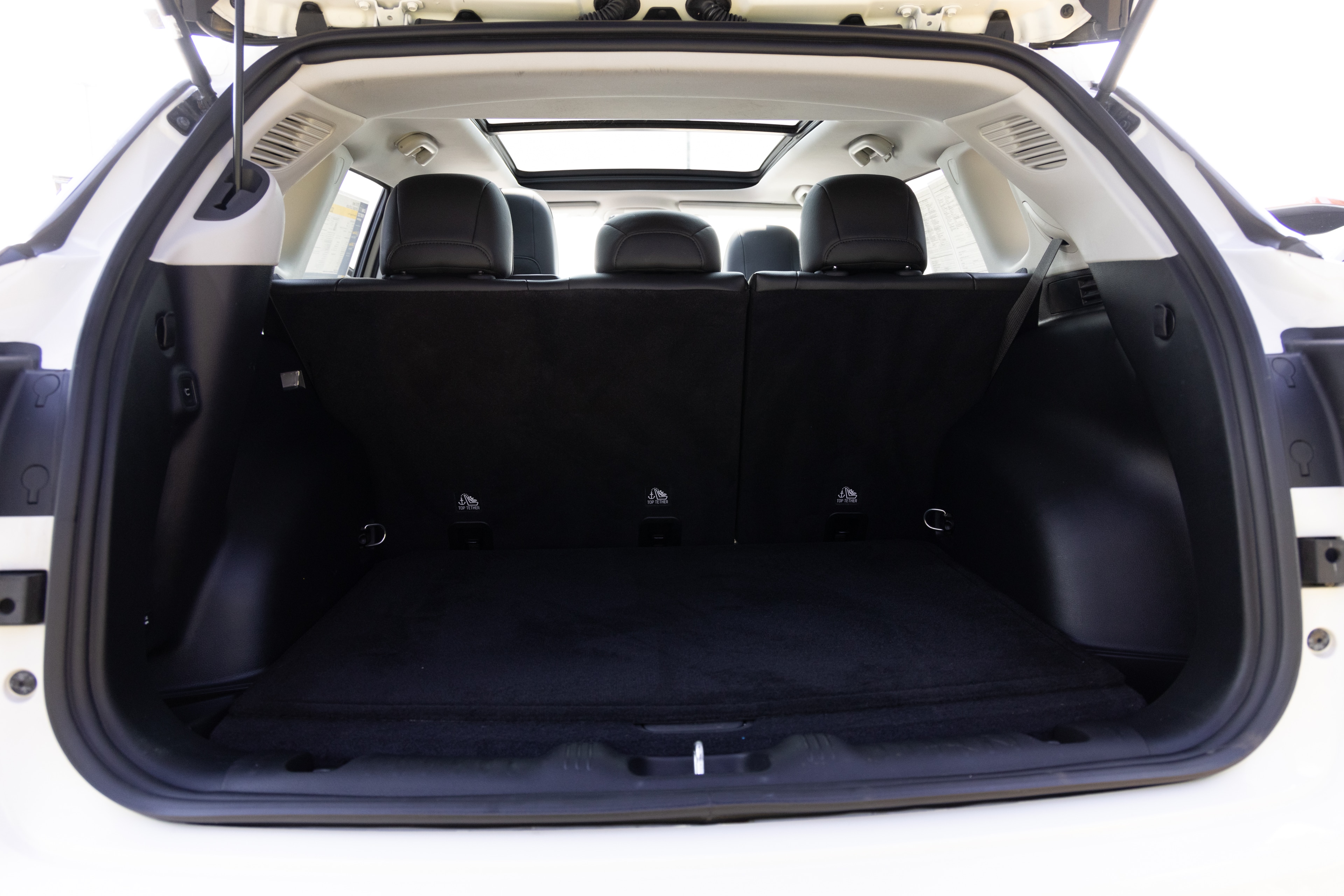The cargo area is open giving a full view of the cargo area. Two large and two small suitcases are placed on their sides.