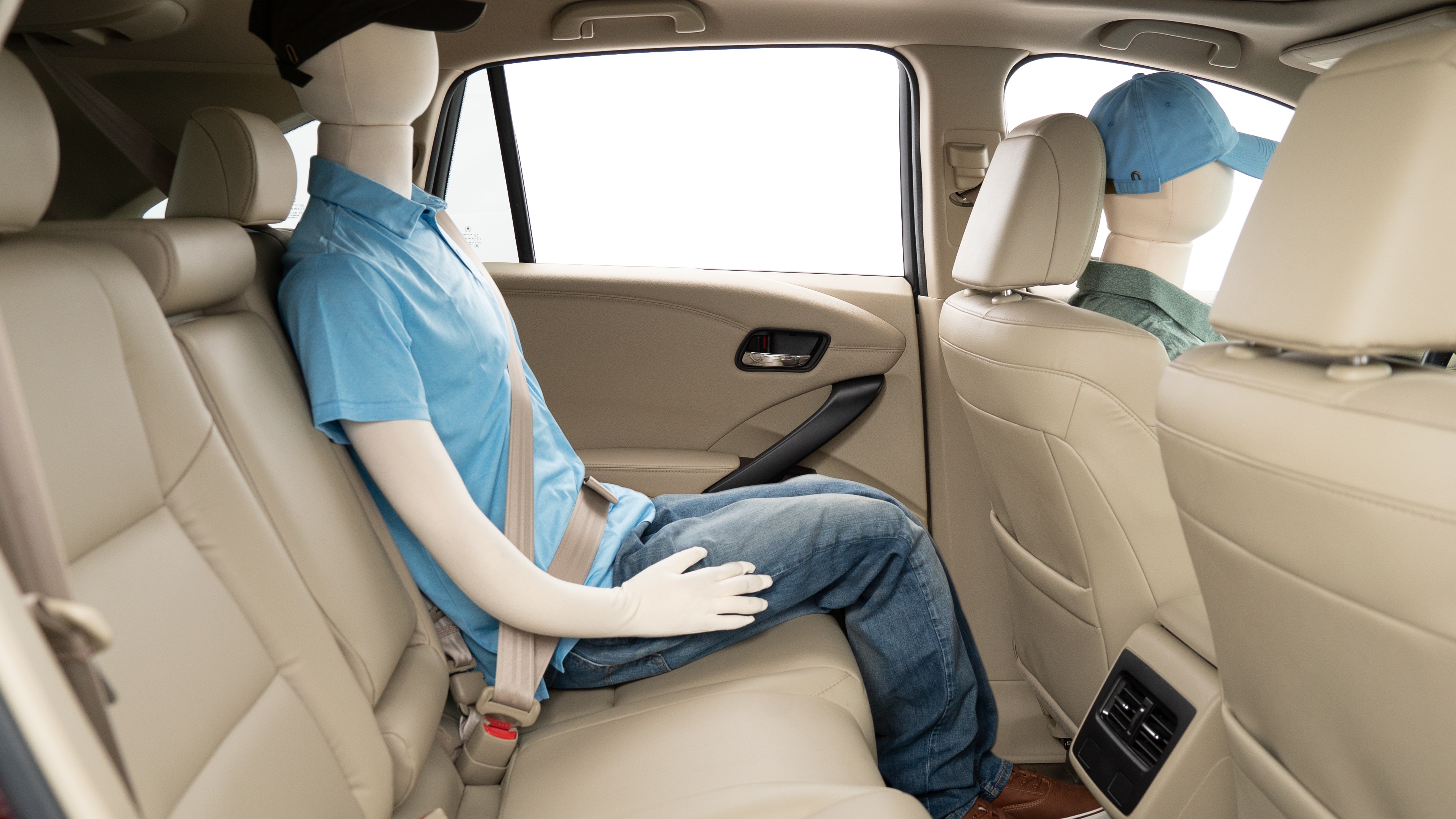 A series of second-row backseat photos is shown including one seating a baby seat, a dog and one seating a 6'1" mannequin.